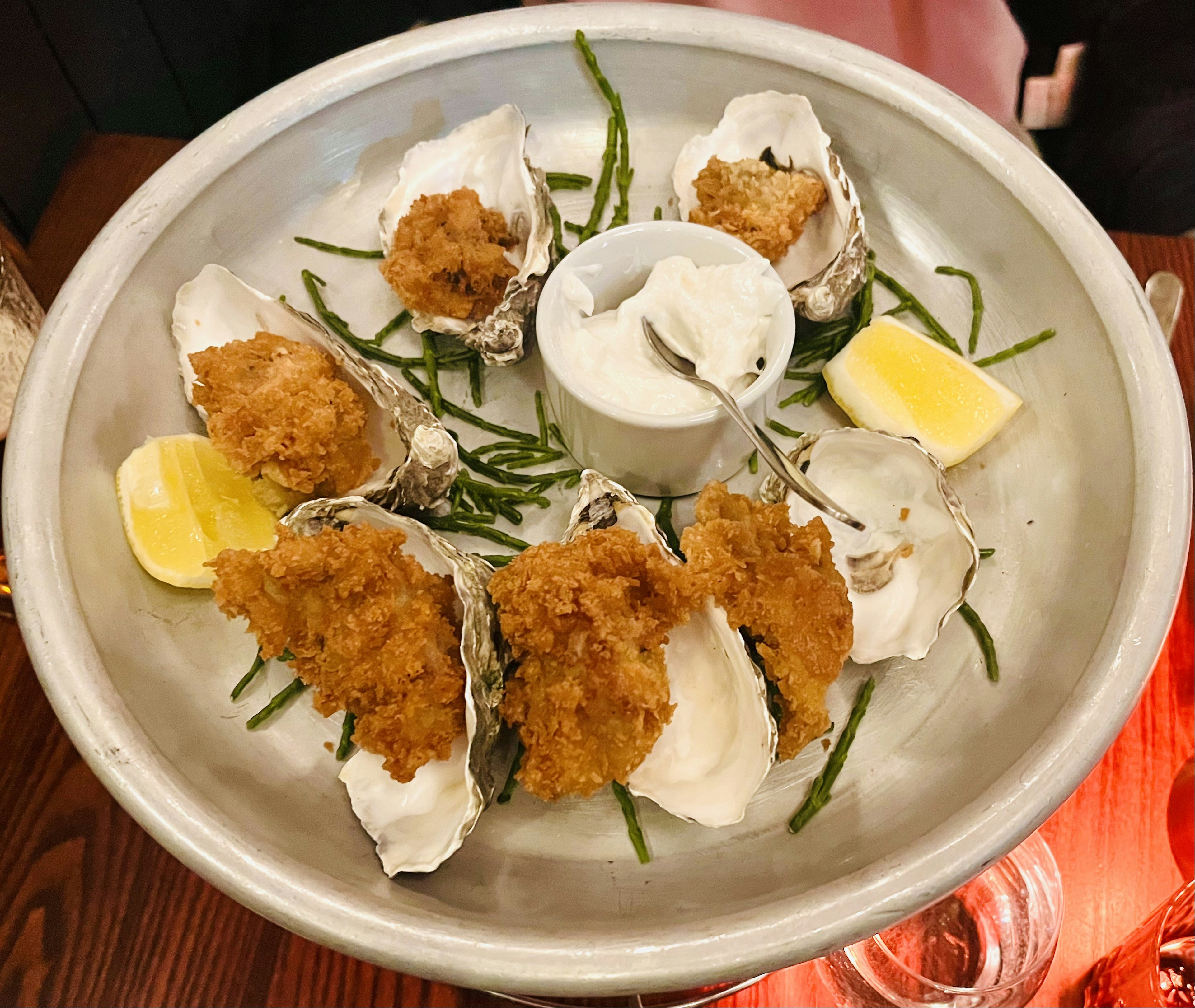 Plate of fried oysters and raw oysters garnished with lemon and dipping sauce