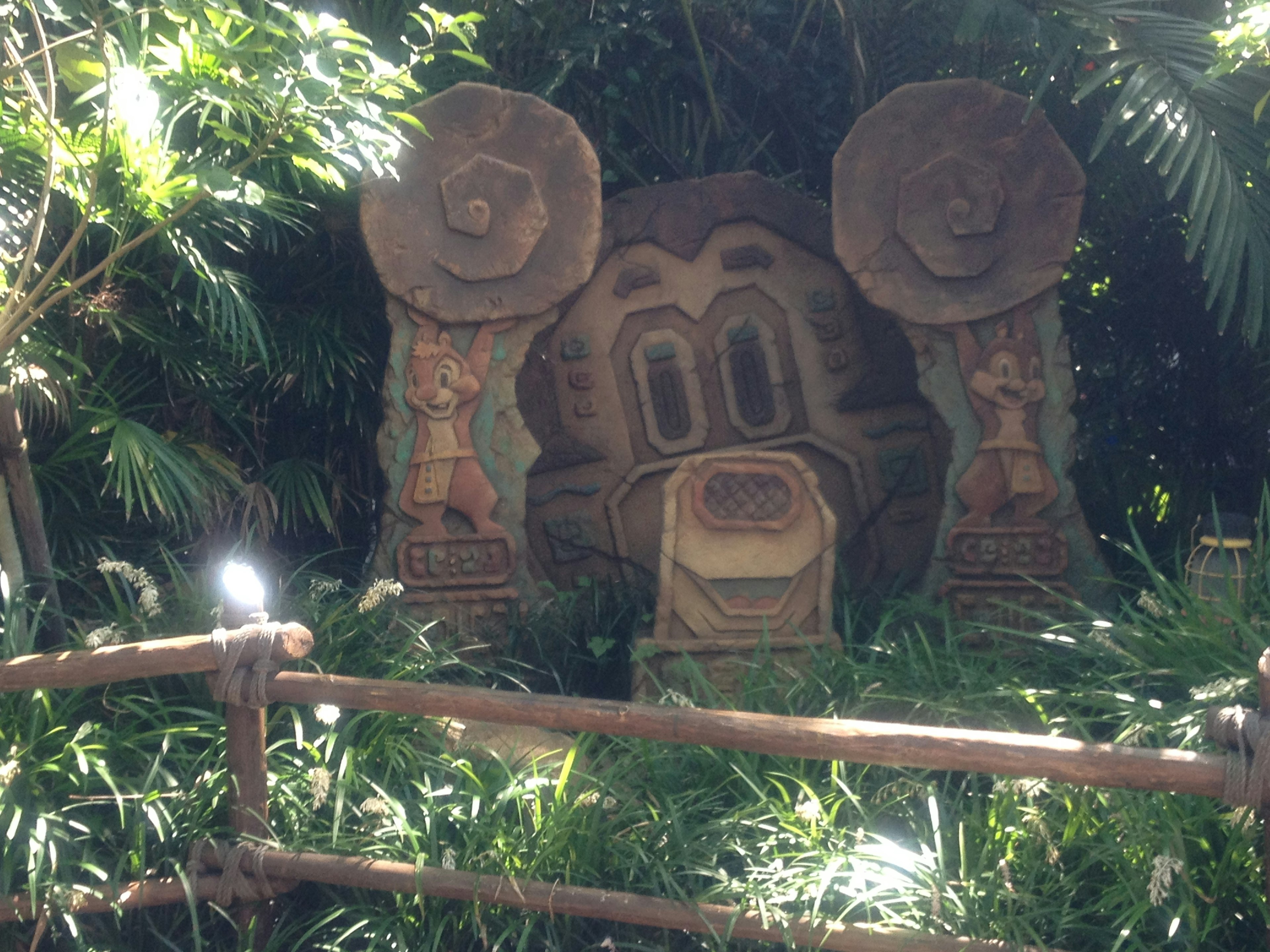 Escultura de piedra rodeada de vegetación exuberante con columnas decorativas