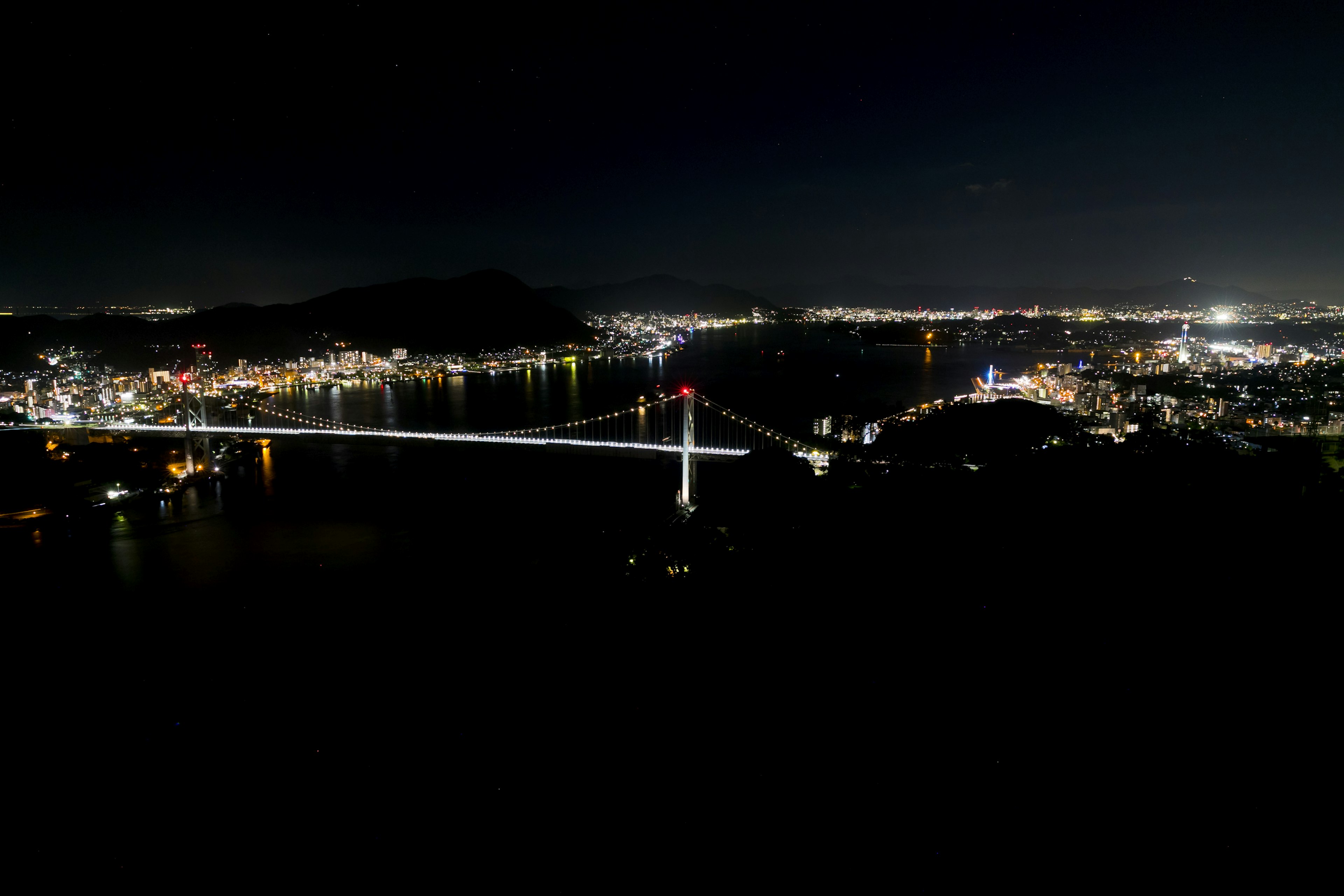 Puente iluminado y luces de la ciudad de noche