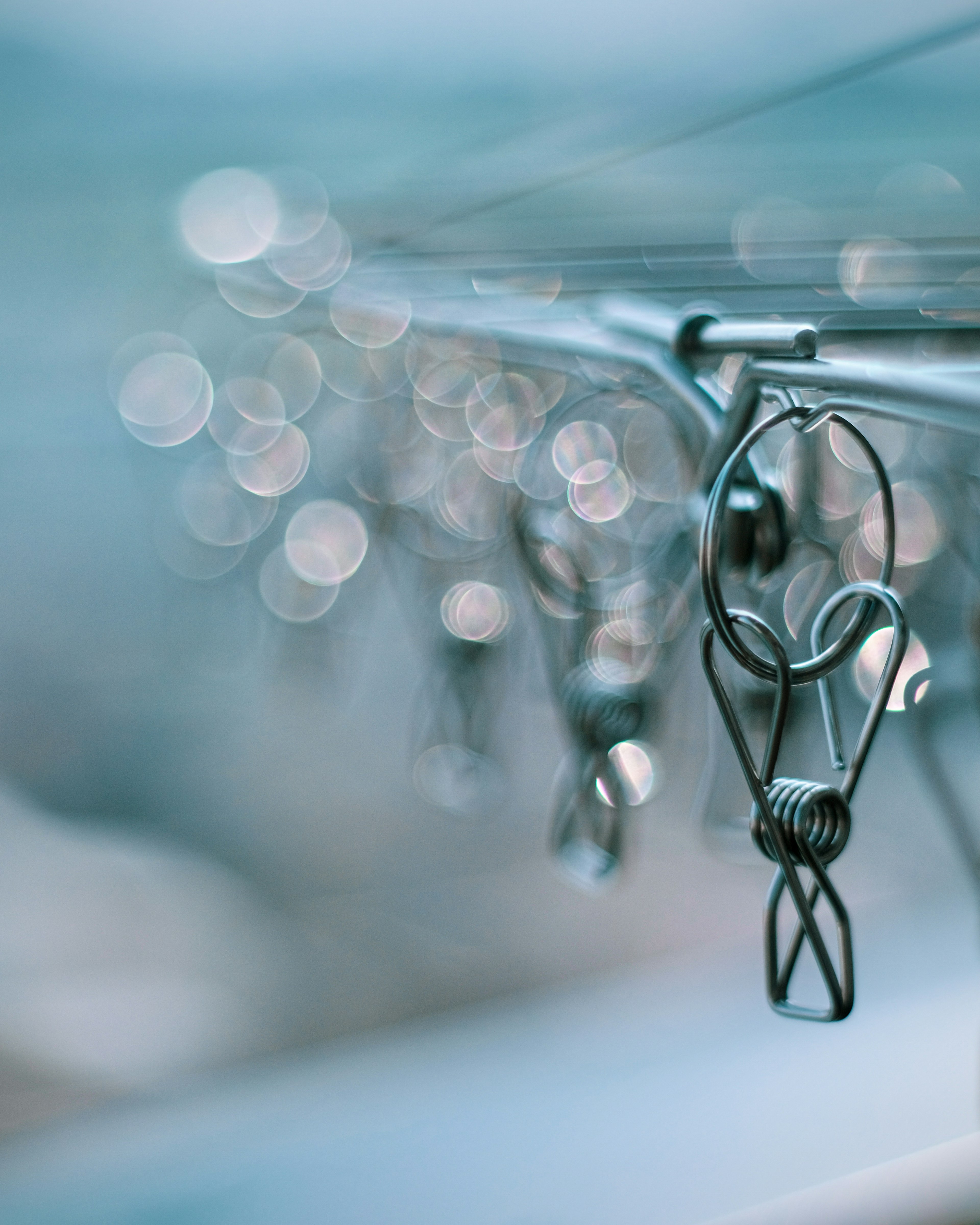 Close-up of metal clips on a wire with a soft blue background