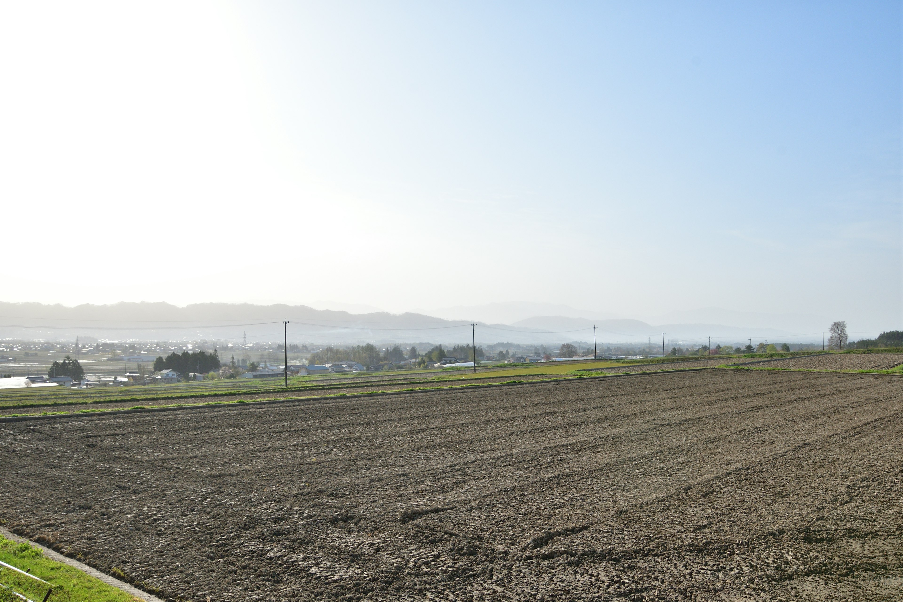 Weite landwirtschaftliche Fläche unter klarem blauen Himmel