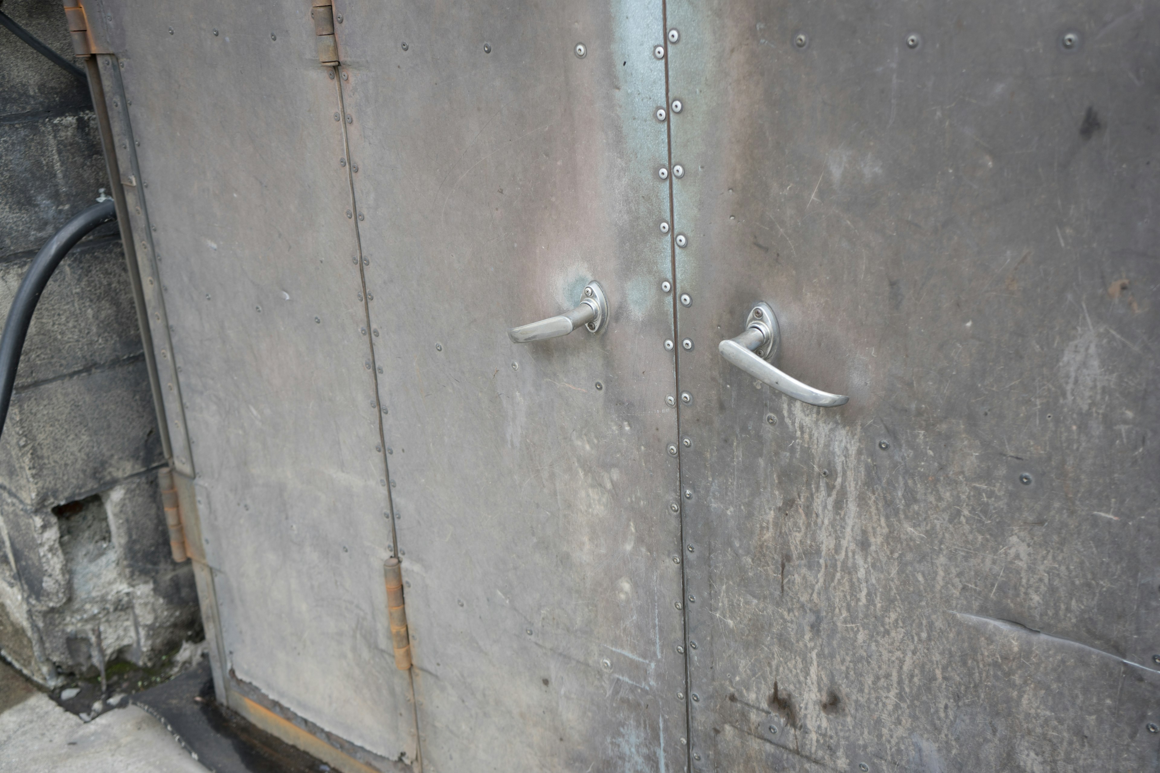 Close-up of a metallic door showing rust and scratches