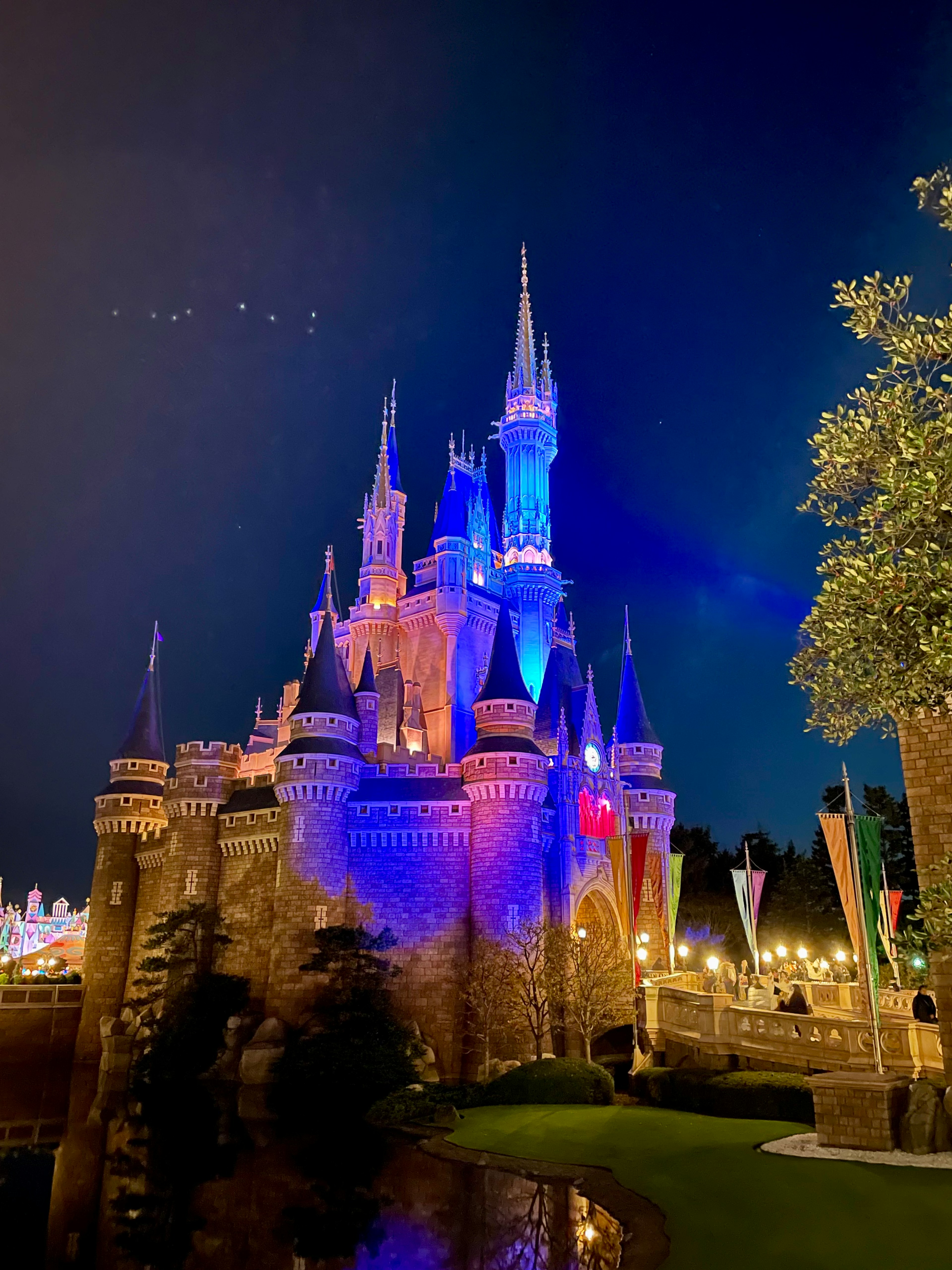 Un beau château de conte de fées illuminé par des lumières bleues la nuit