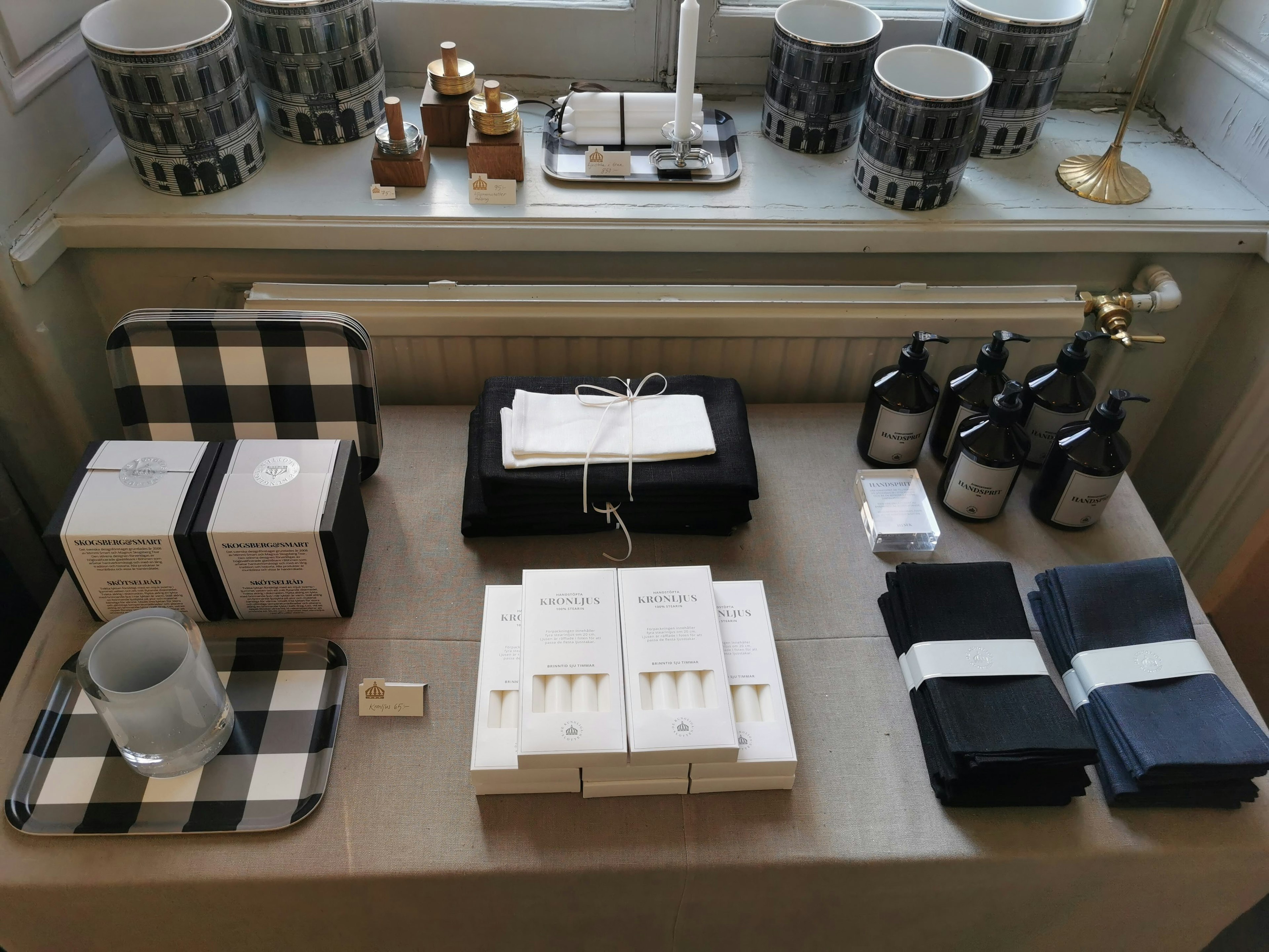 A neatly arranged display of luxury towels, candles, and toiletries on a table with a checkered tray