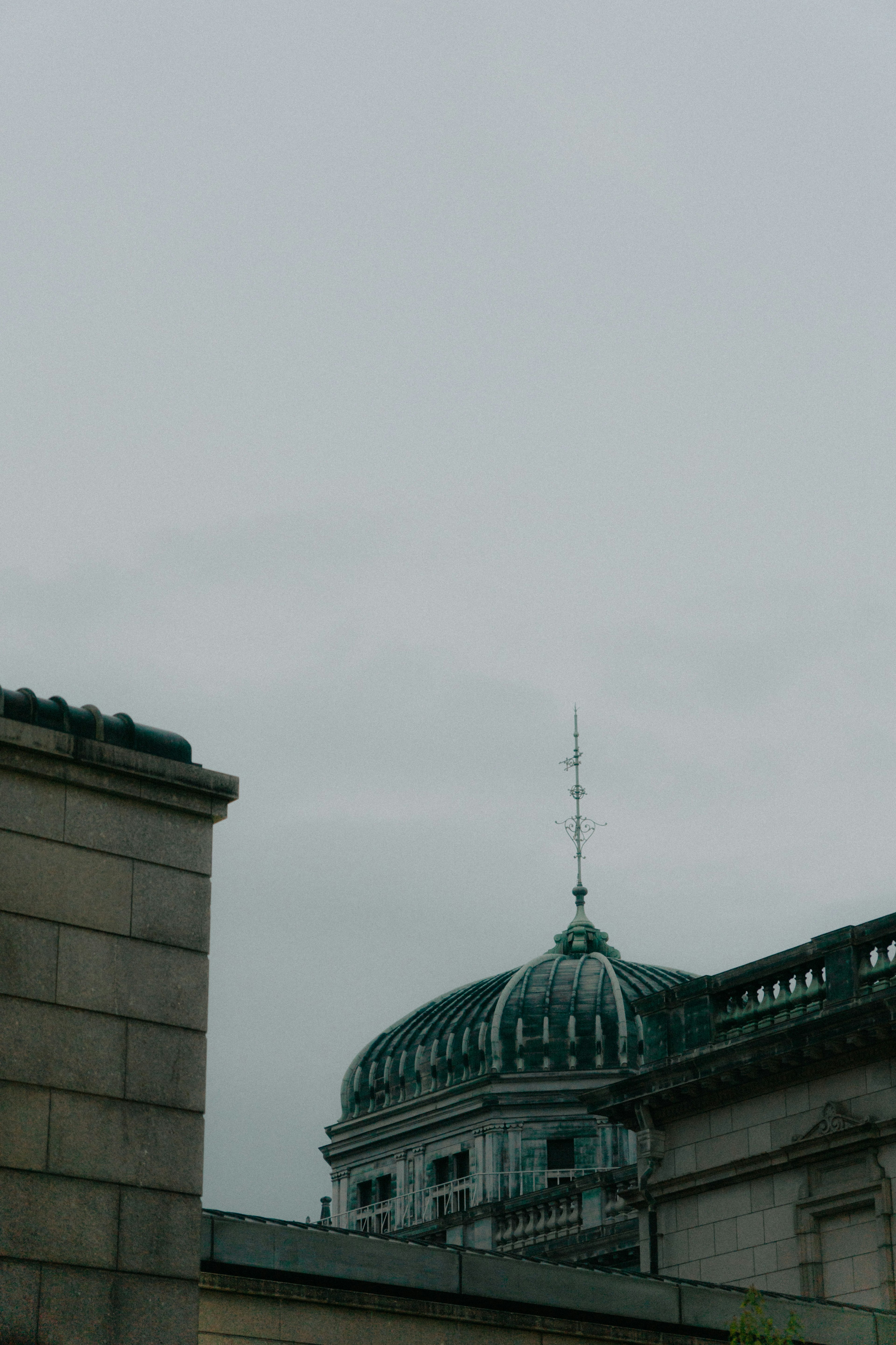 Cupola di un edificio storico con guglia sotto un cielo grigio