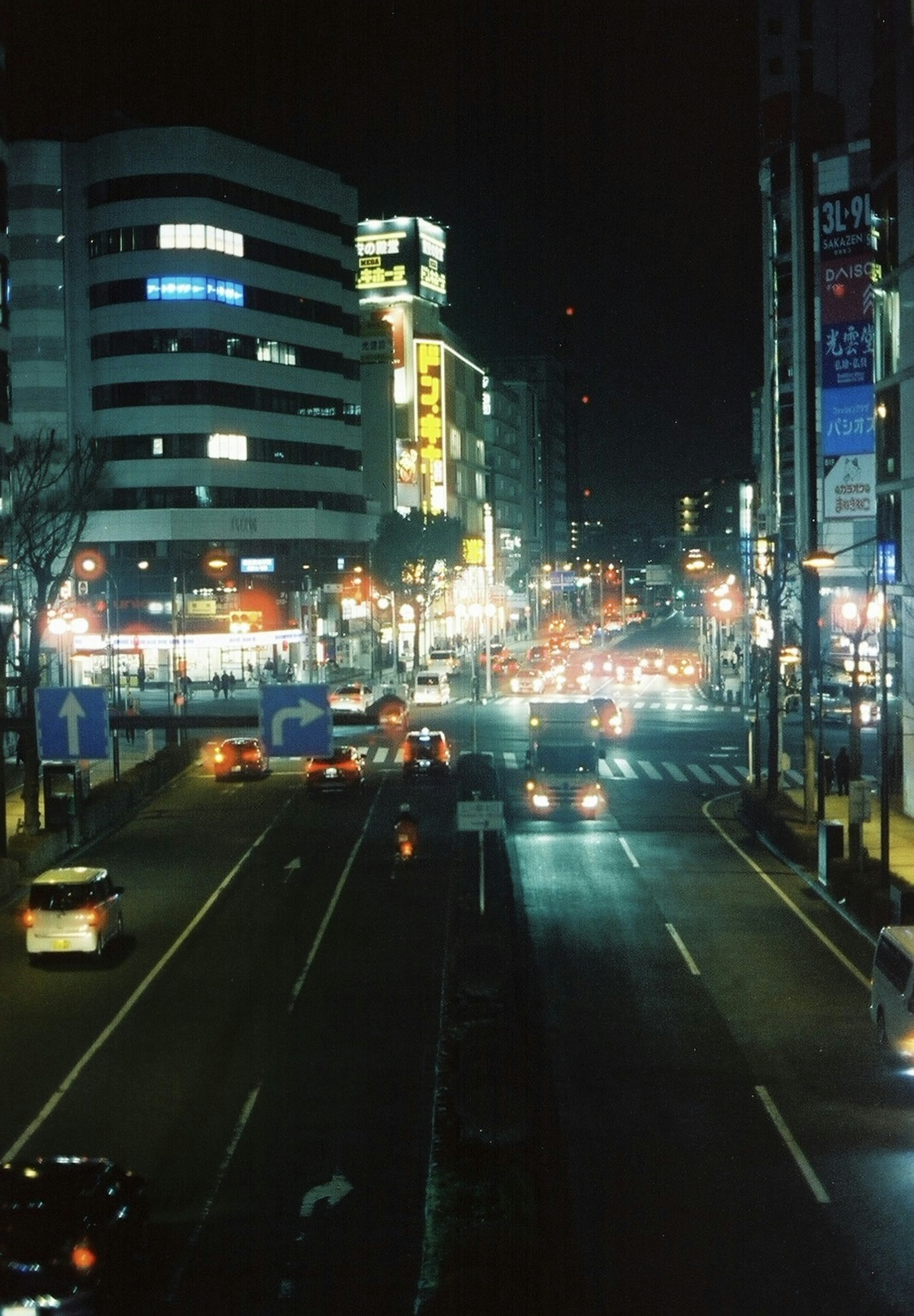 Pemandangan kota malam dengan lampu jalan yang terang dan kendaraan