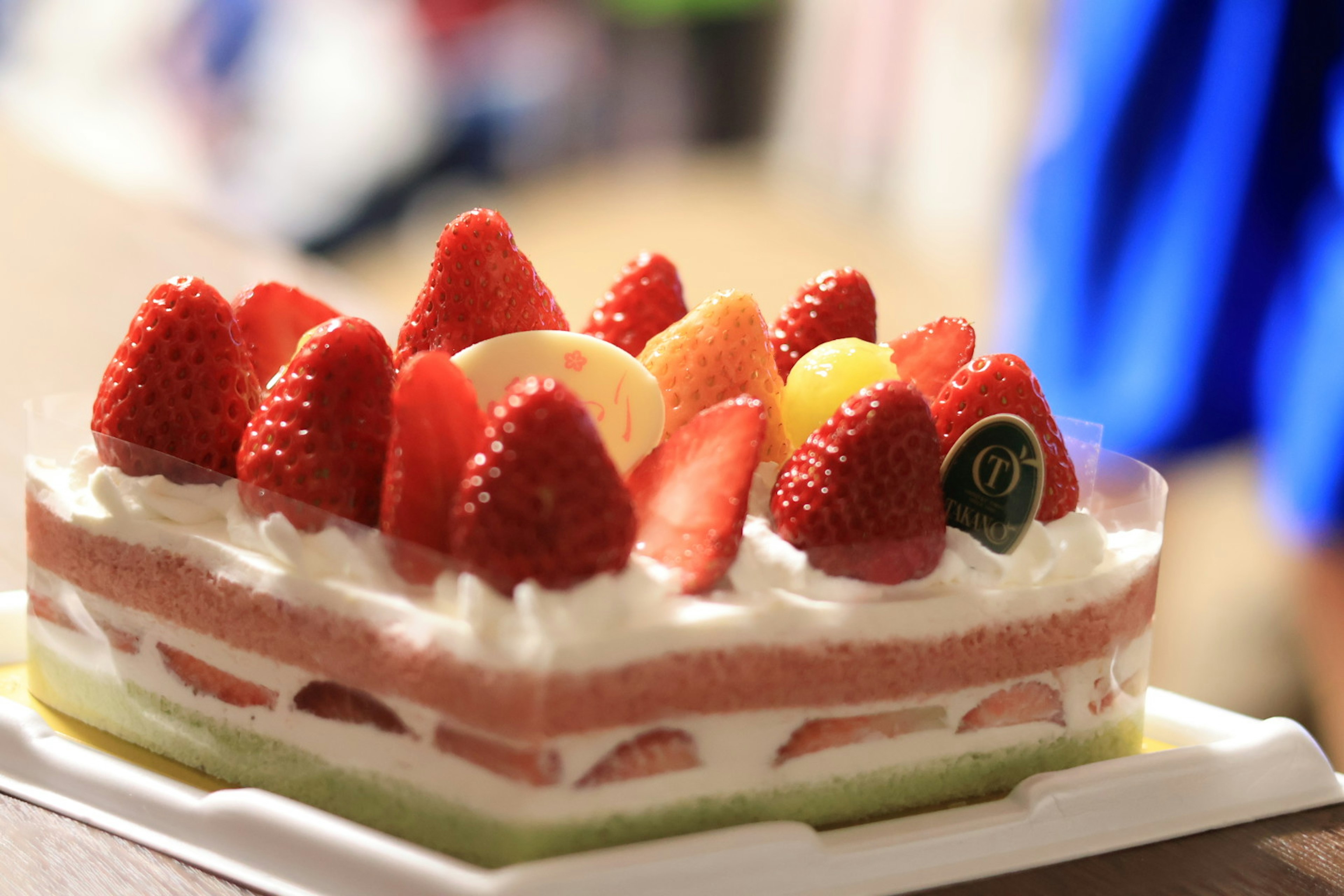 Cream cake topped with colorful fruits including strawberries and blueberries