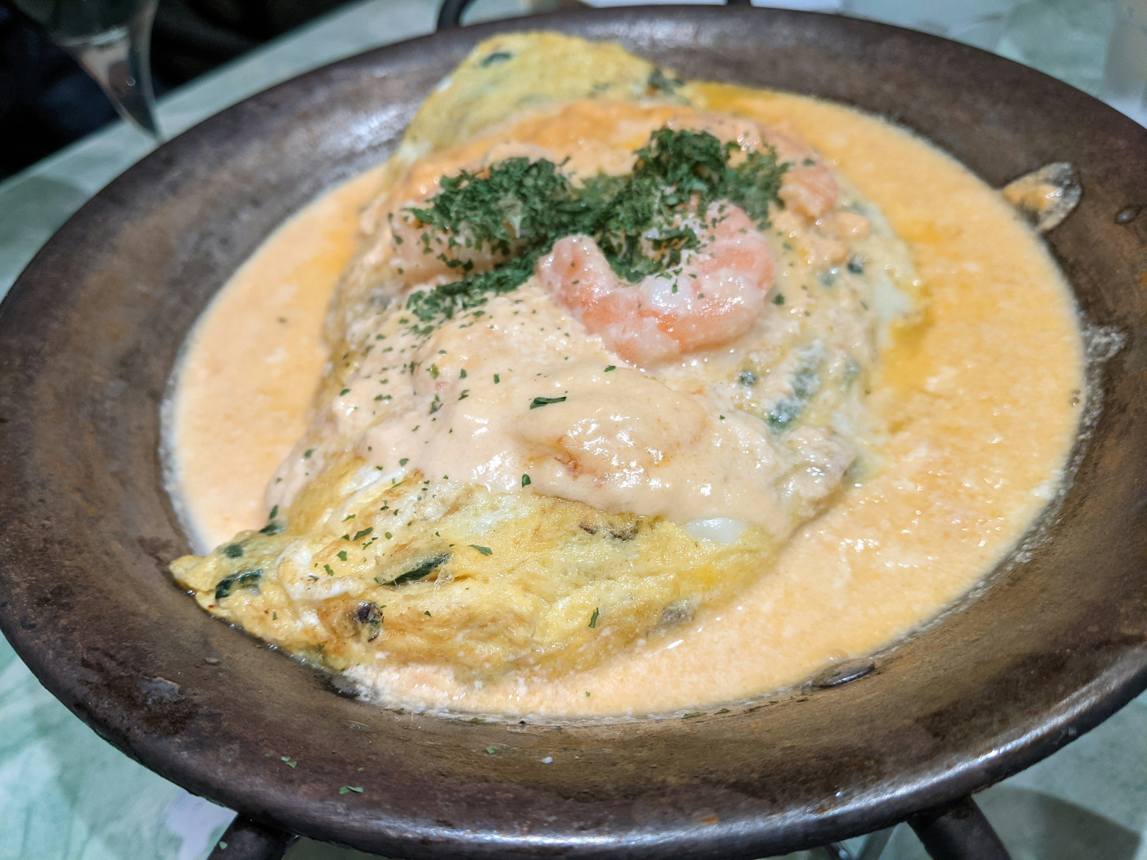 Tortilla cubierta con salsa cremosa de camarones y perejil