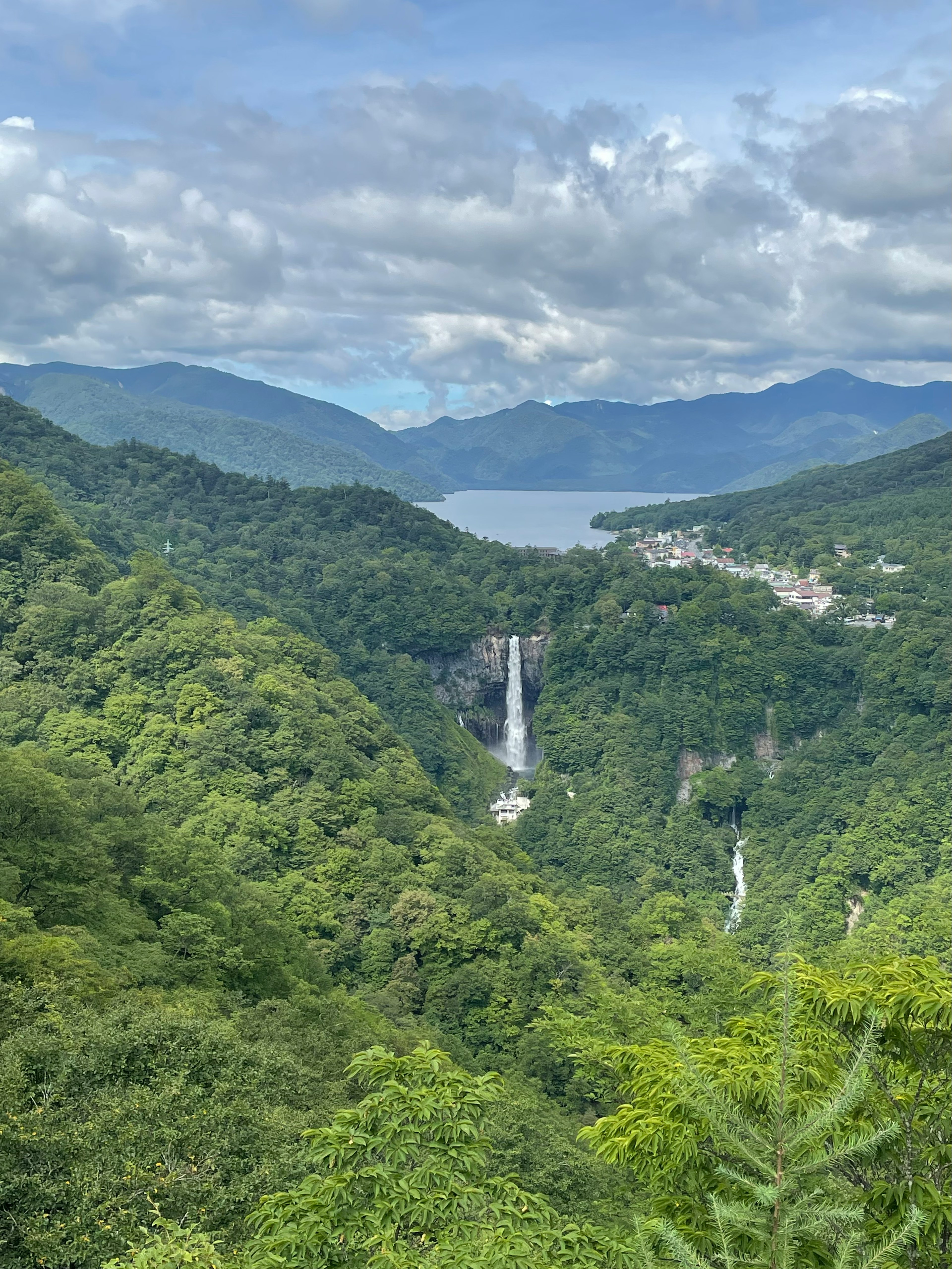 青々とした山々と滝が見える風景 湖と雲が広がる空