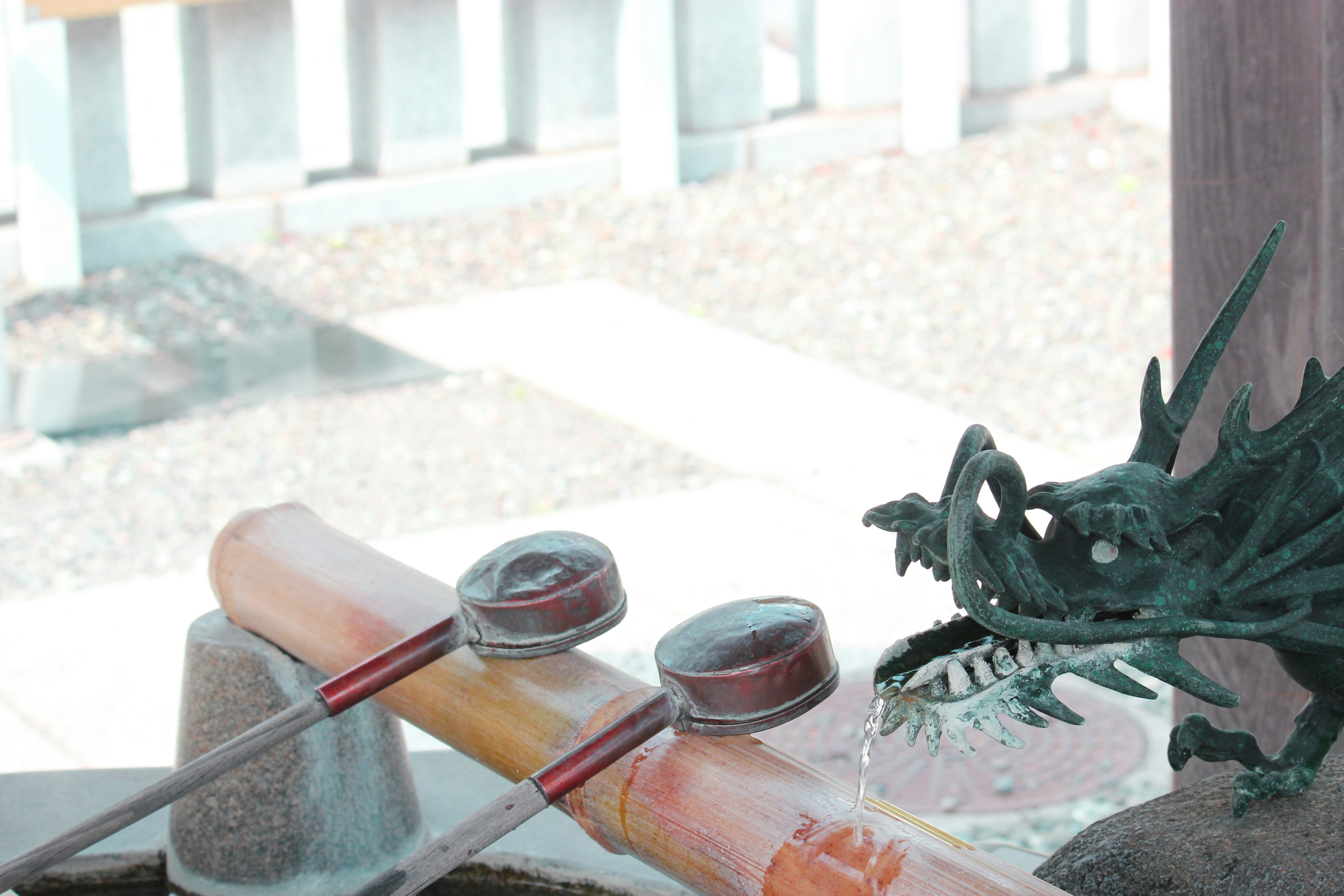 Japanese garden scene featuring a water basin and dragon sculpture