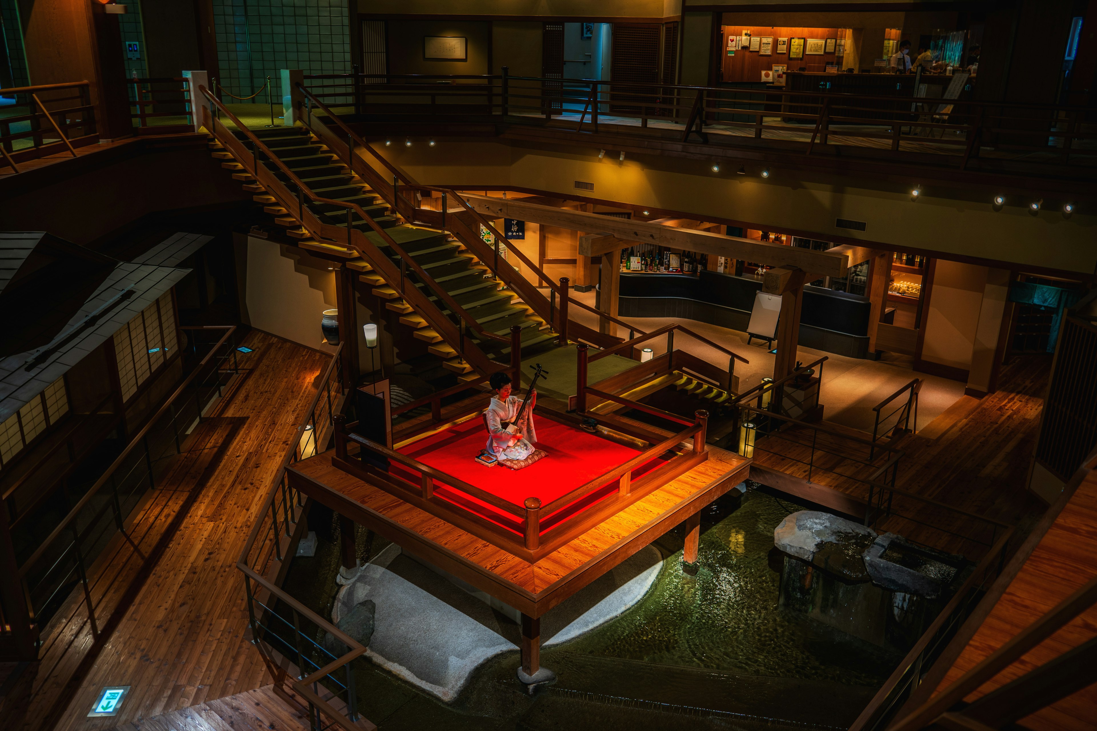 Interior of a beautiful wooden building featuring a red stage surrounded by stairs and lighting