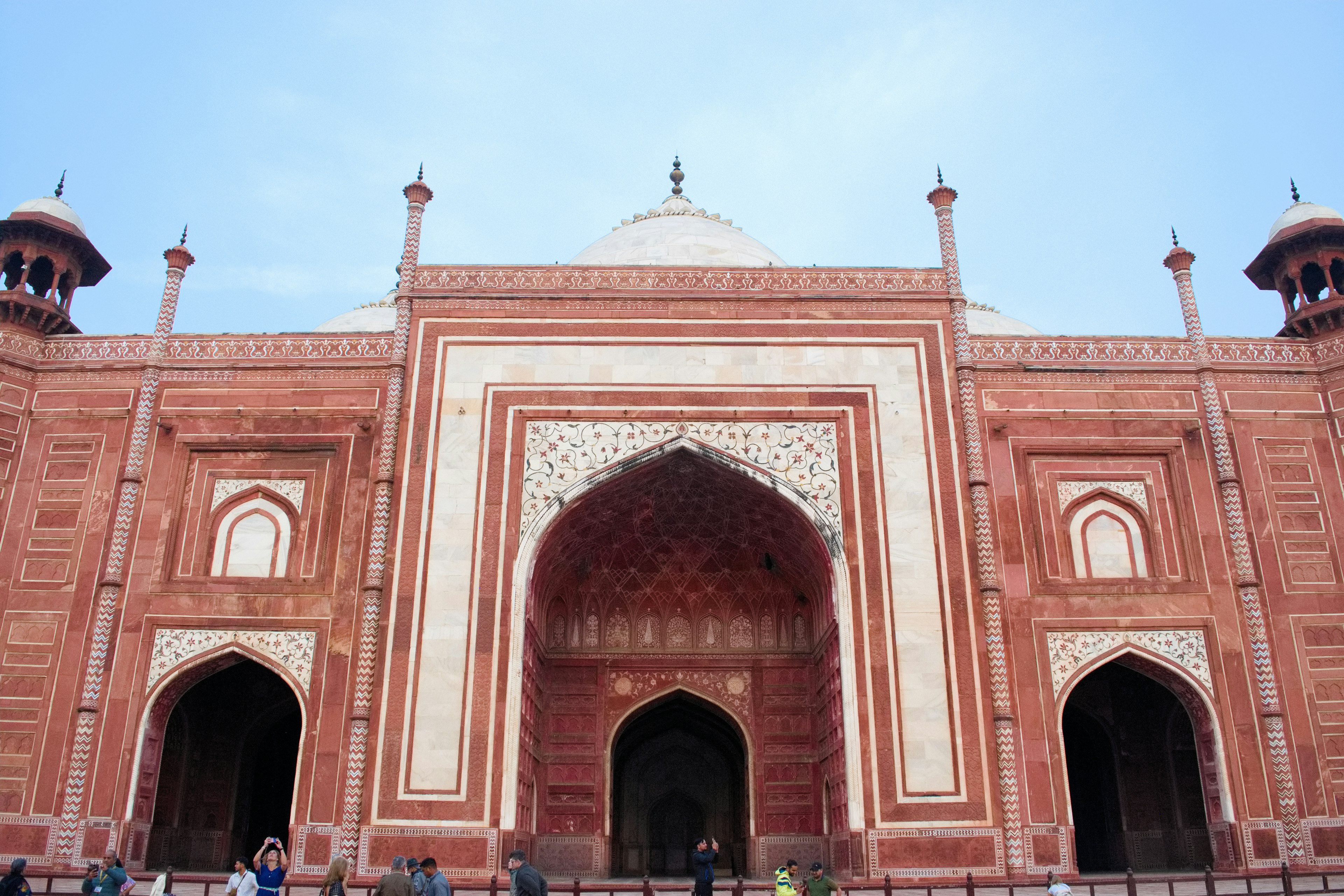 Grand entrance arch of the Taj Mahal with intricate red stone architecture