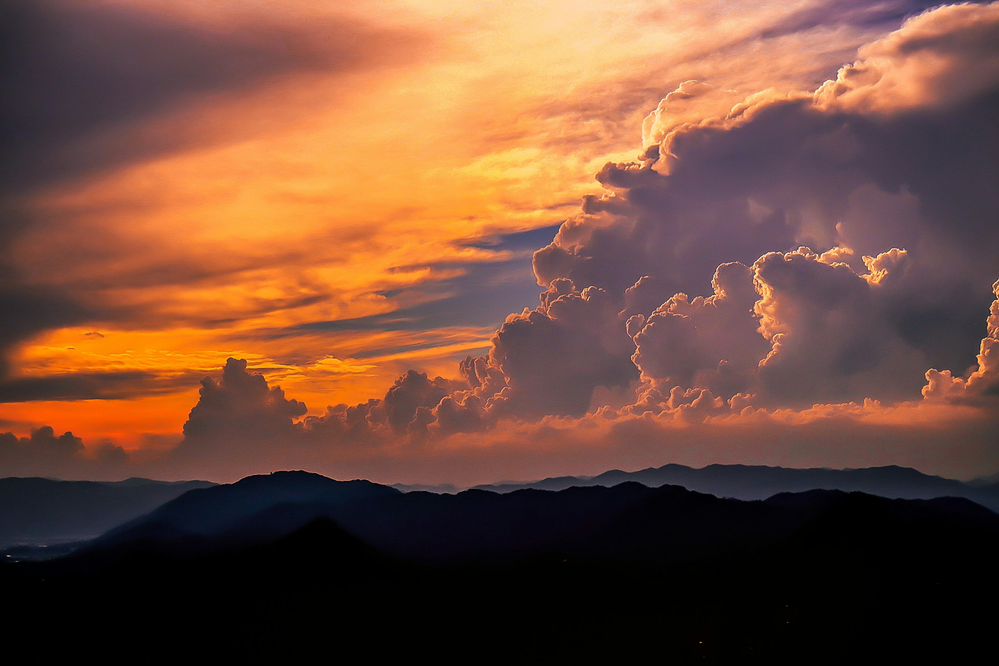 Pemandangan dengan awan senja berwarna-warni dan pegunungan