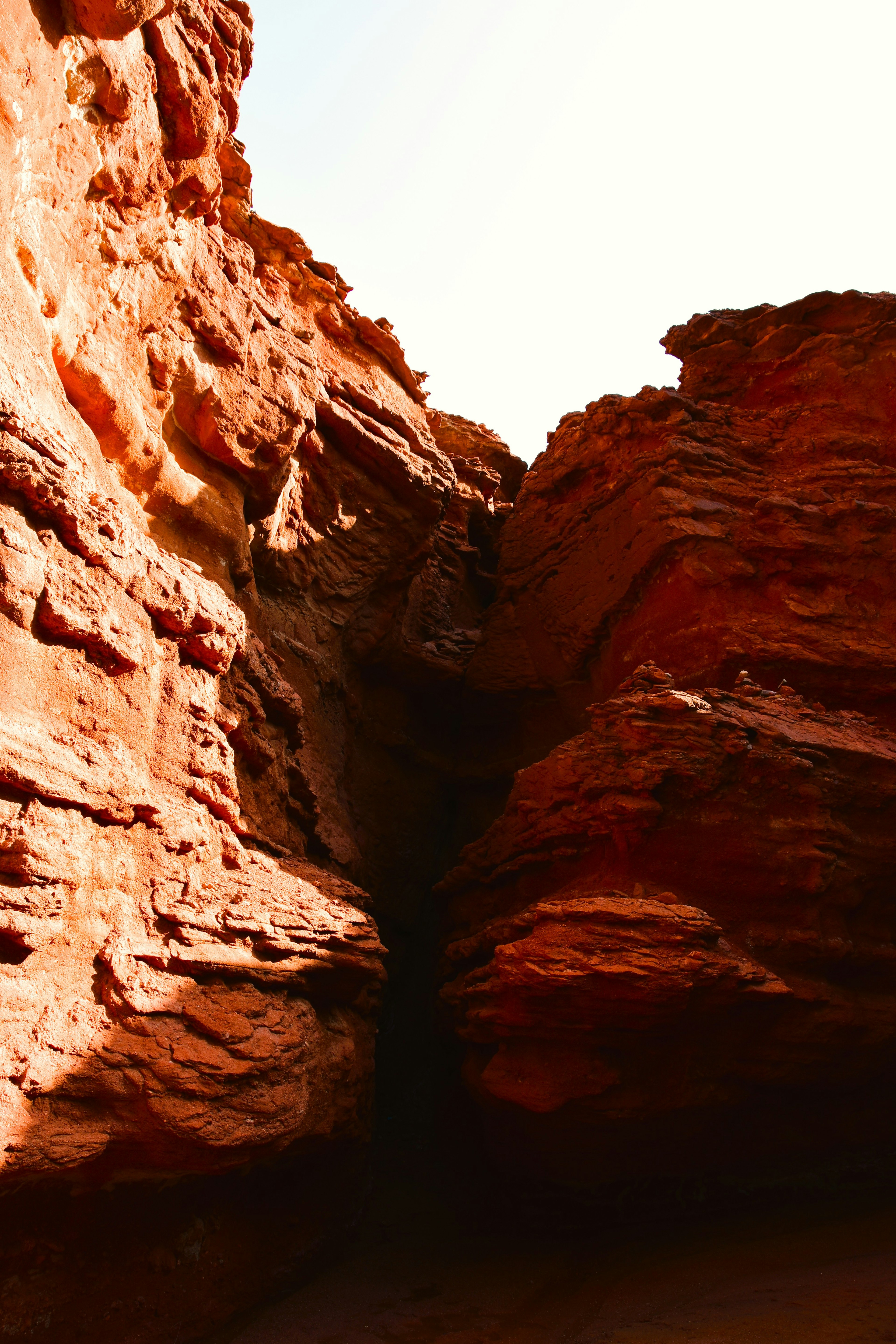 Stretto passaggio in un canyon di rocce rosse con cielo luminoso