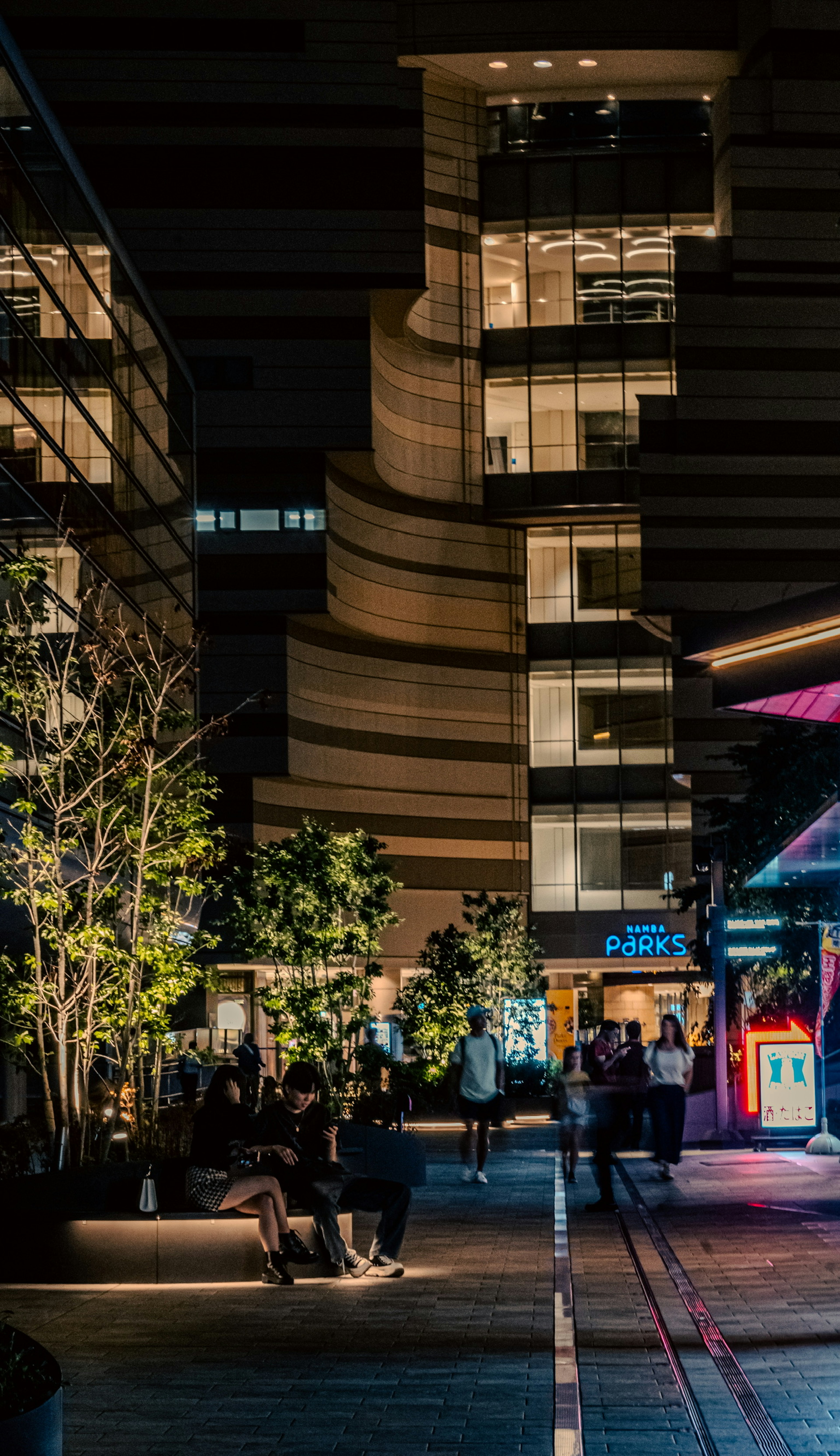 Edificio moderno in un ambiente urbano notturno con vegetazione