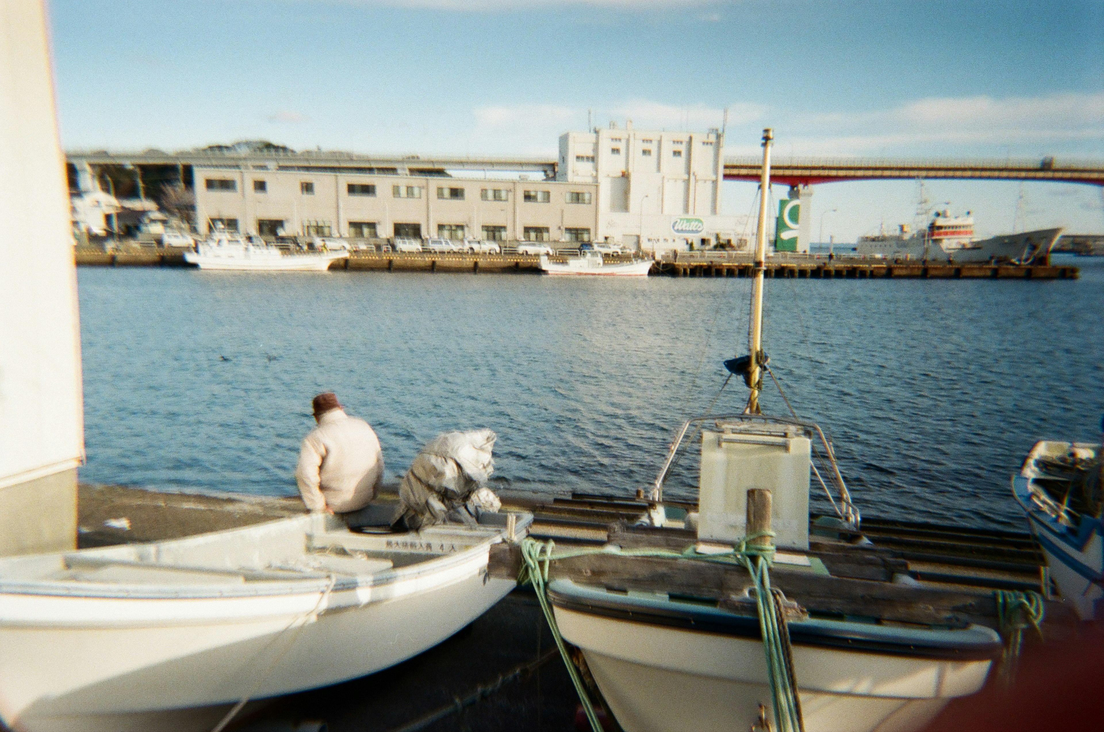 A man working on small boats in a quiet harbor