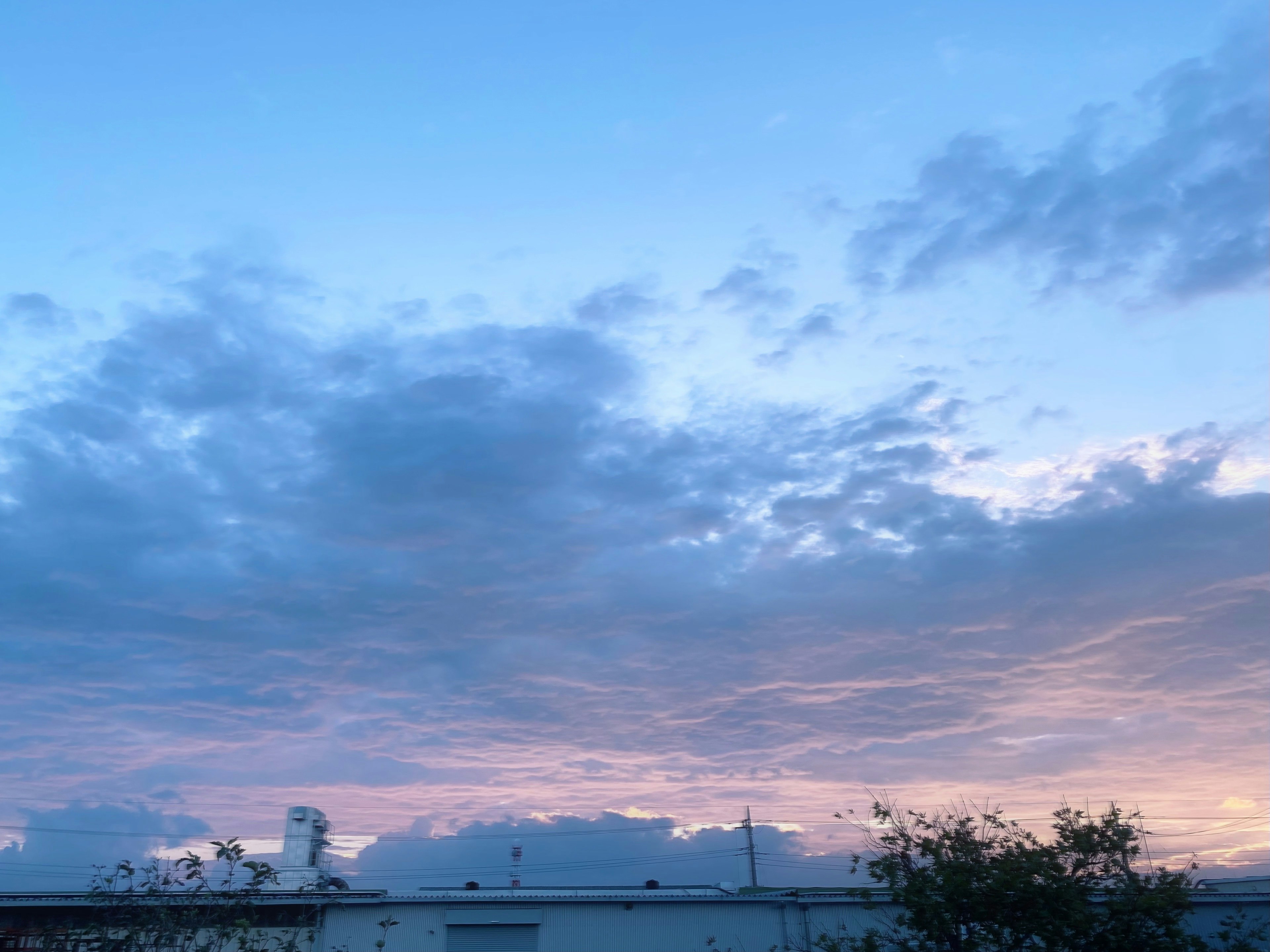 青い空と雲に覆われた夕焼けの景色