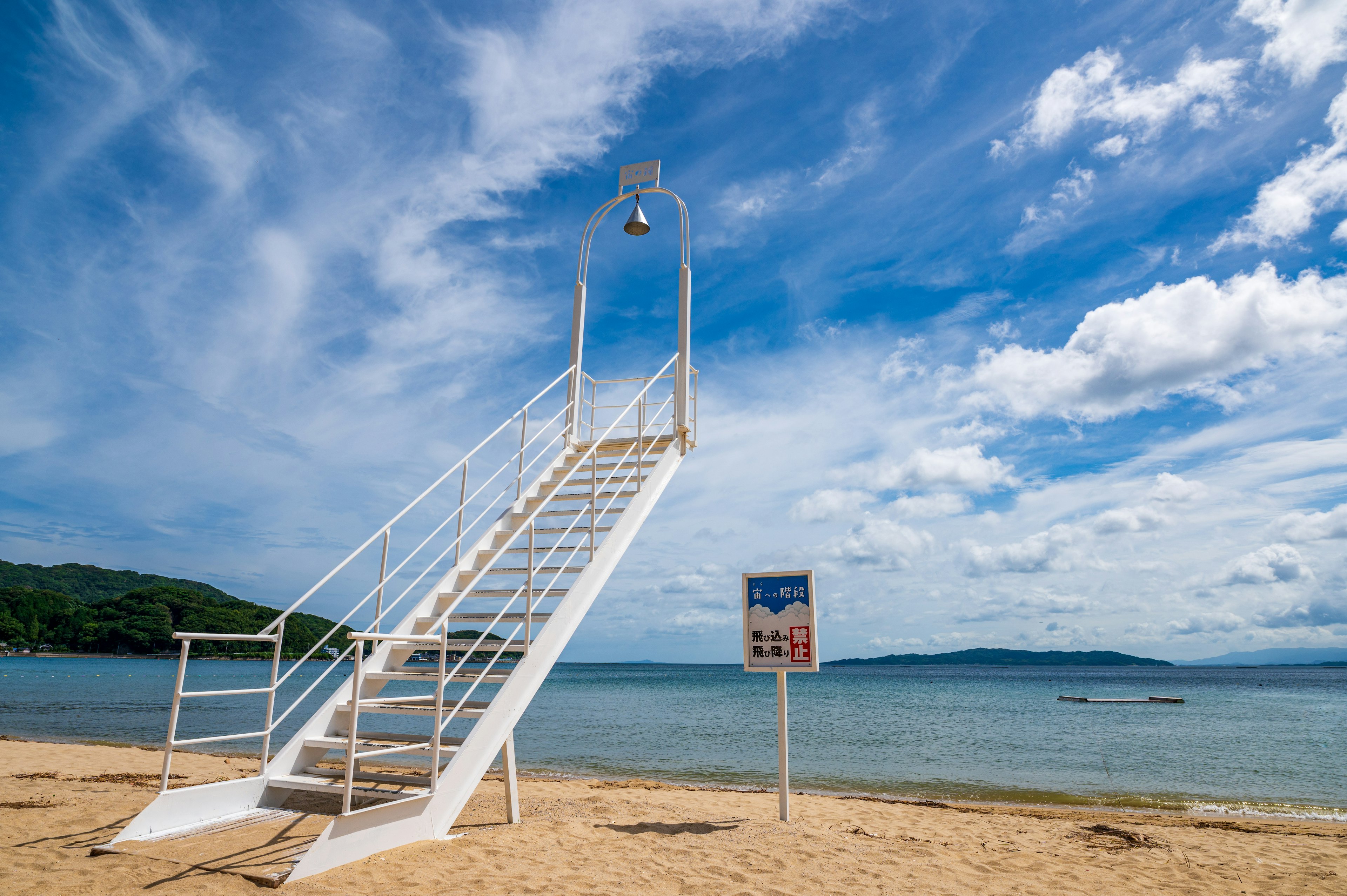 ทิวทัศน์ชายหาดที่มีหอคอยยามสีขาวใต้ท้องฟ้าสีฟ้า