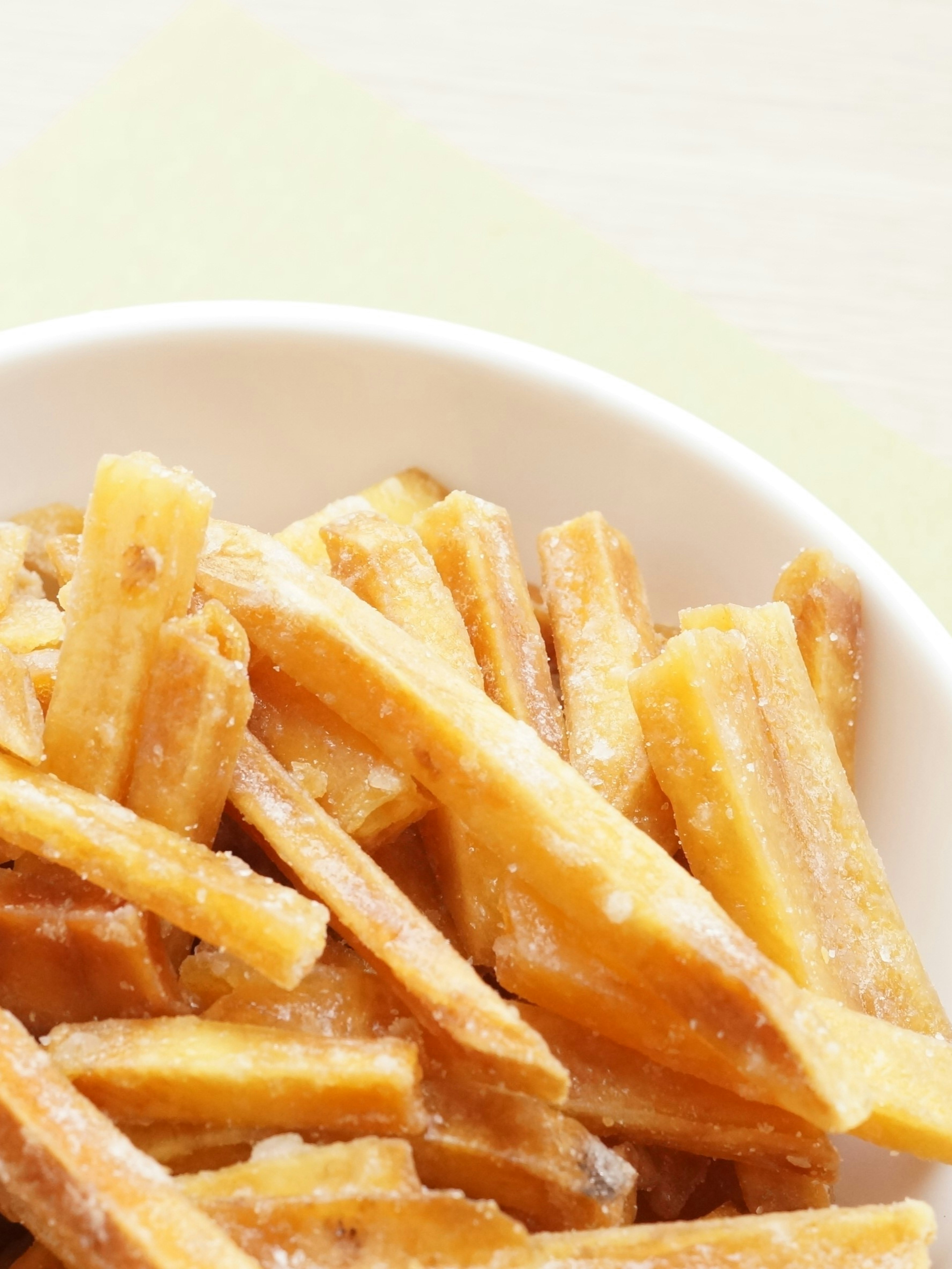 Golden crispy snack sticks in a white bowl