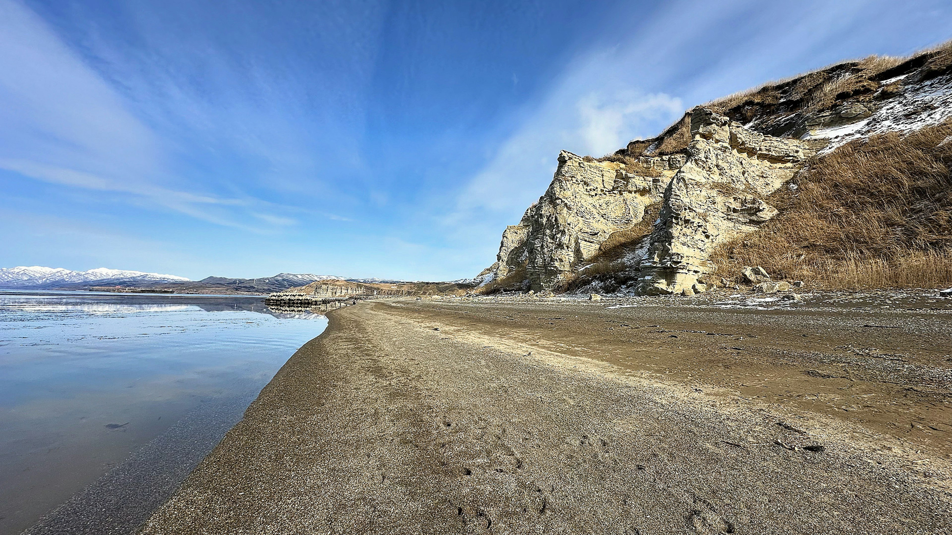 Paesaggio di spiaggia con cielo azzurro e scogliere rocciose