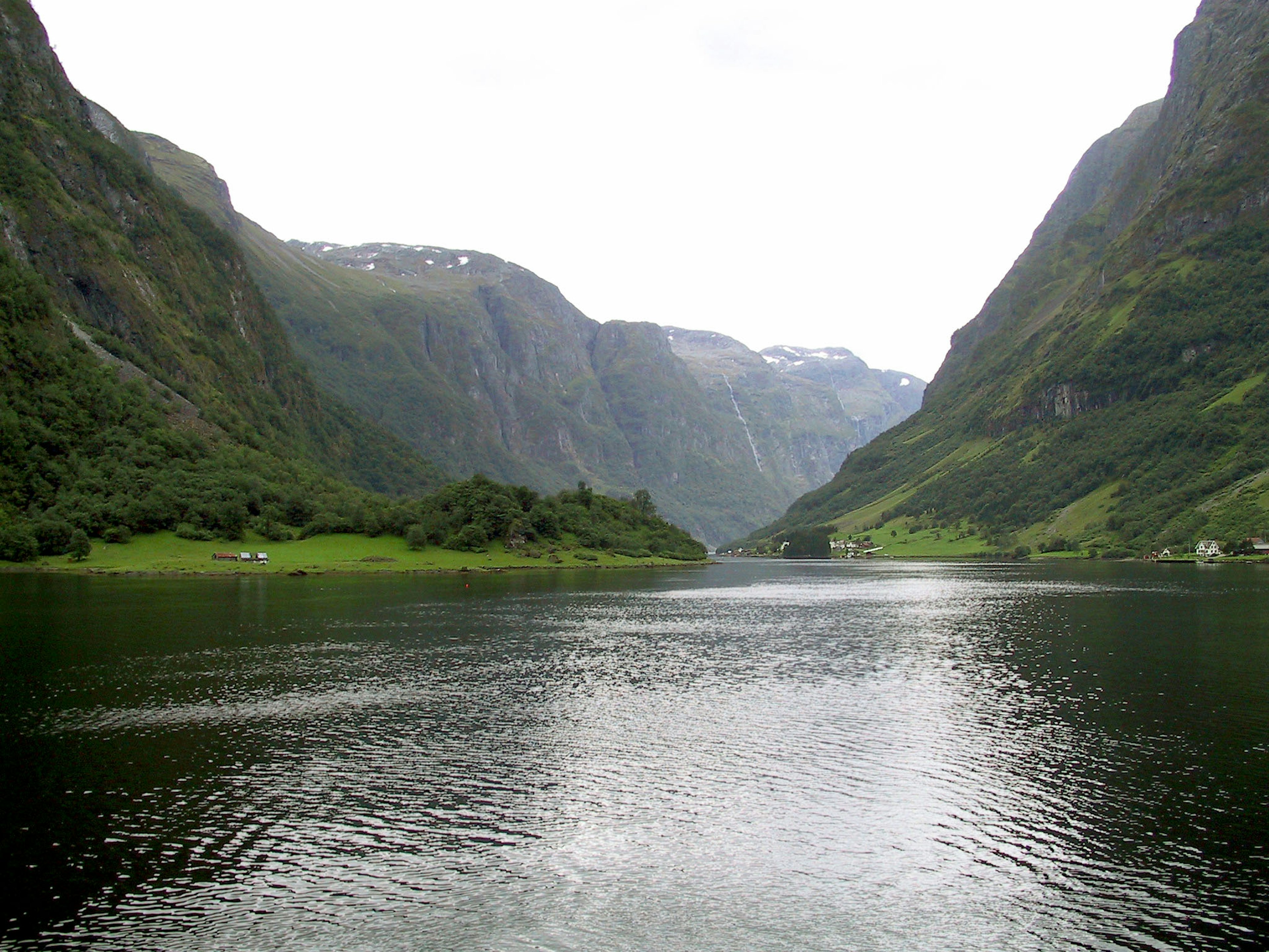 Paisaje de fiordo escénico con montañas verdes y superficie de agua tranquila