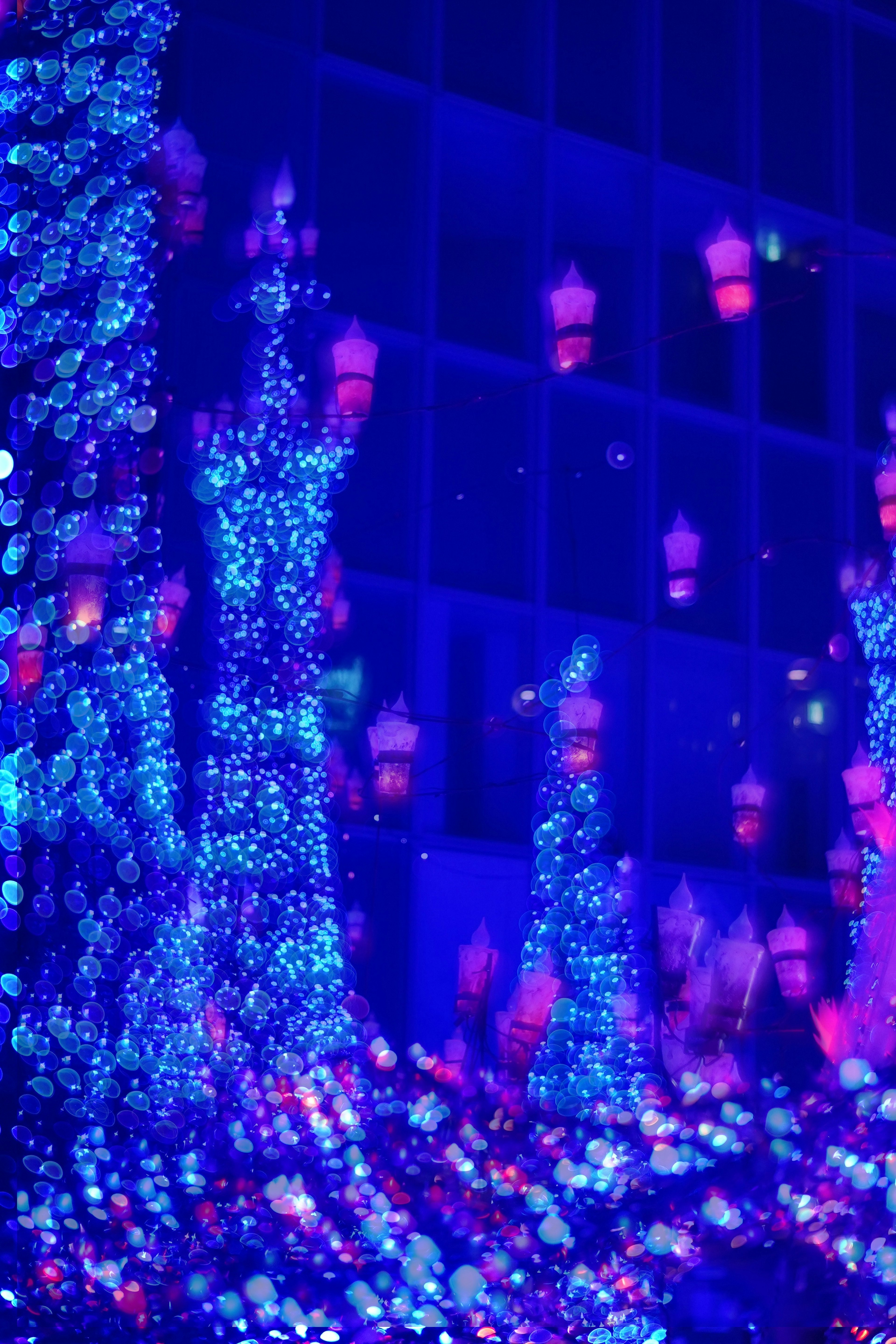 Scène nocturne avec des lumières bleues et des reflets de lanternes rouges