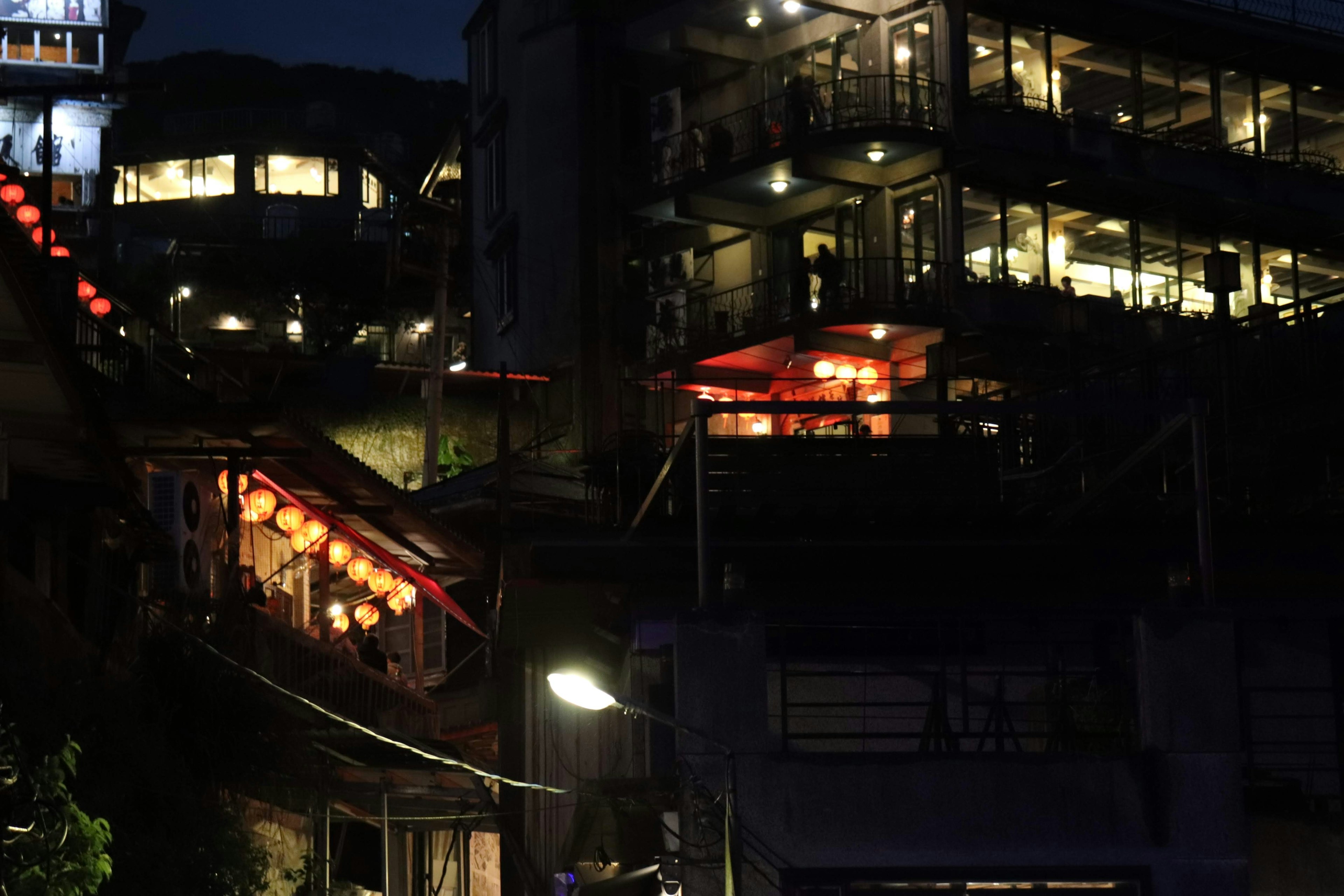 Vista nocturna de edificios iluminados con farolillos rojos y luces