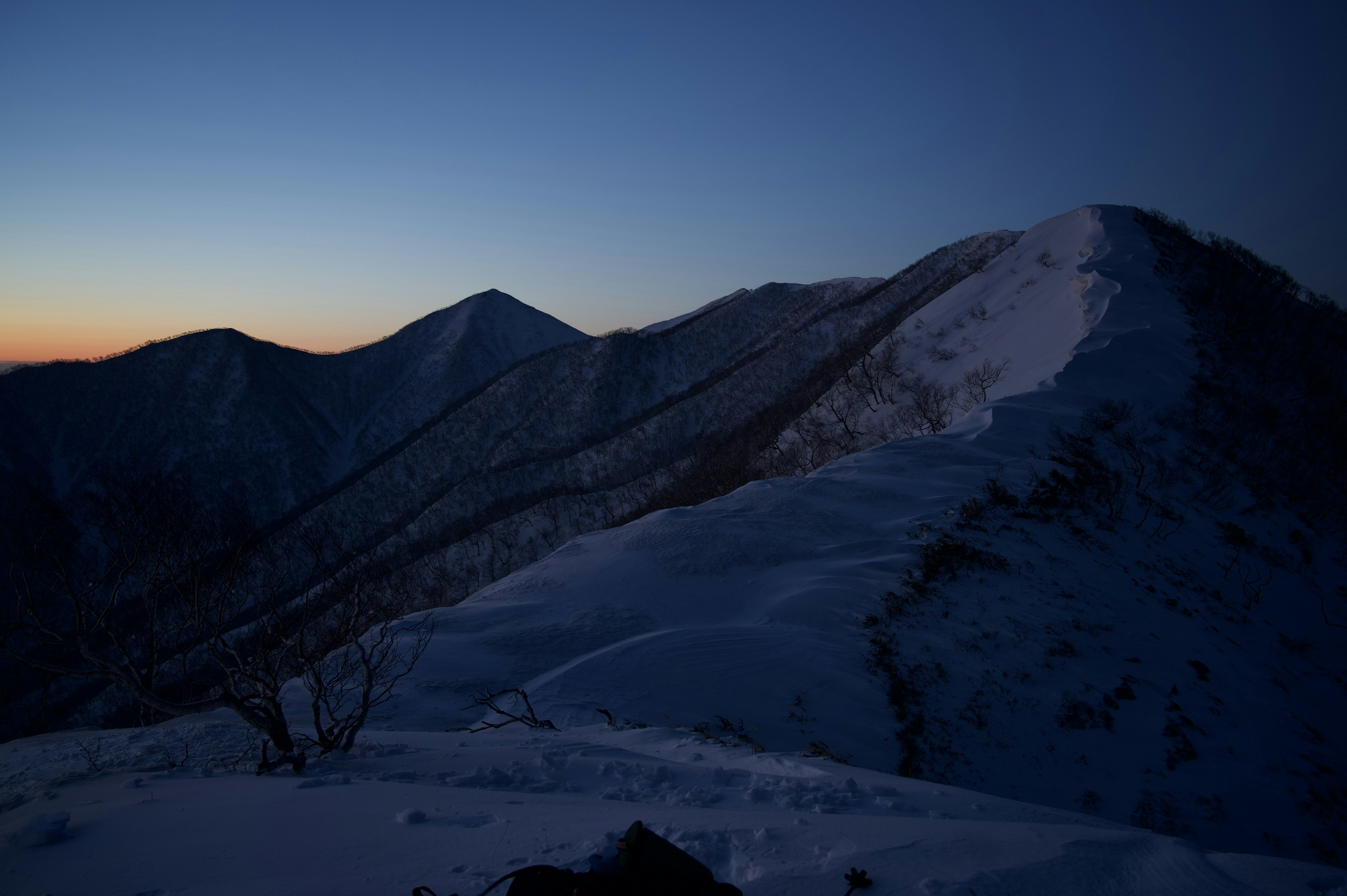 Montagnes enneigées se silhouette contre un ciel crépusculaire