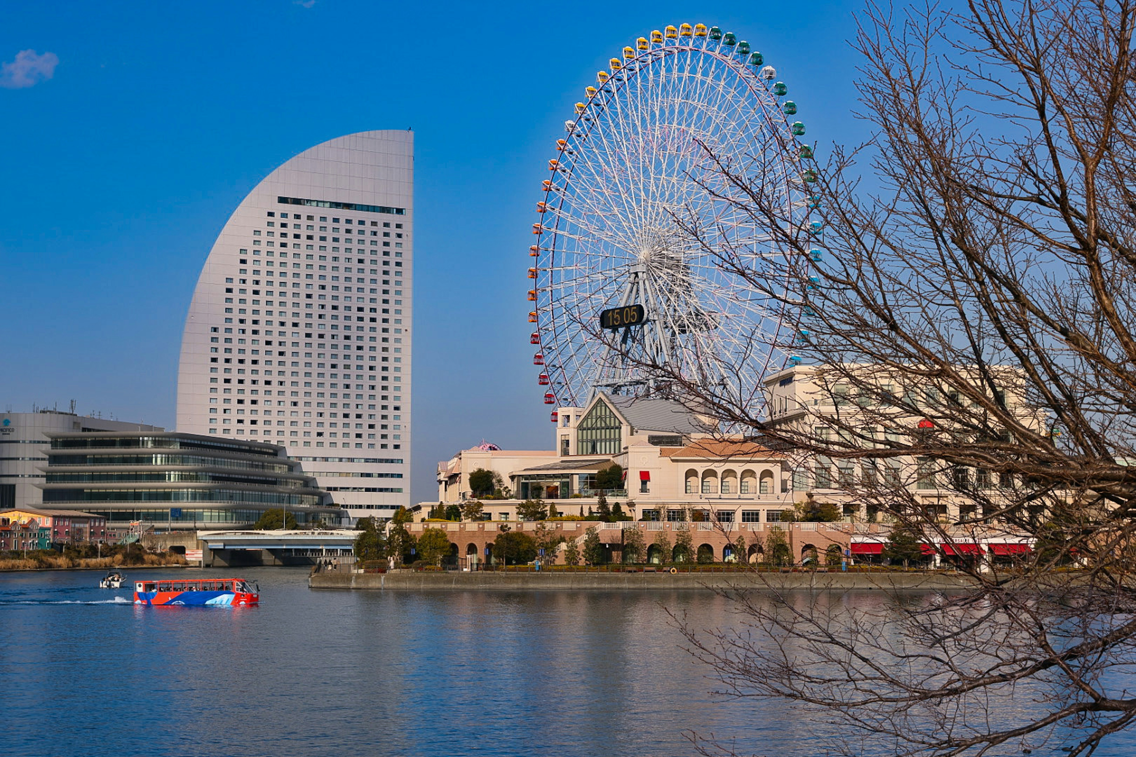 横浜の摩天輪と現代的な建物が映る海沿いの風景