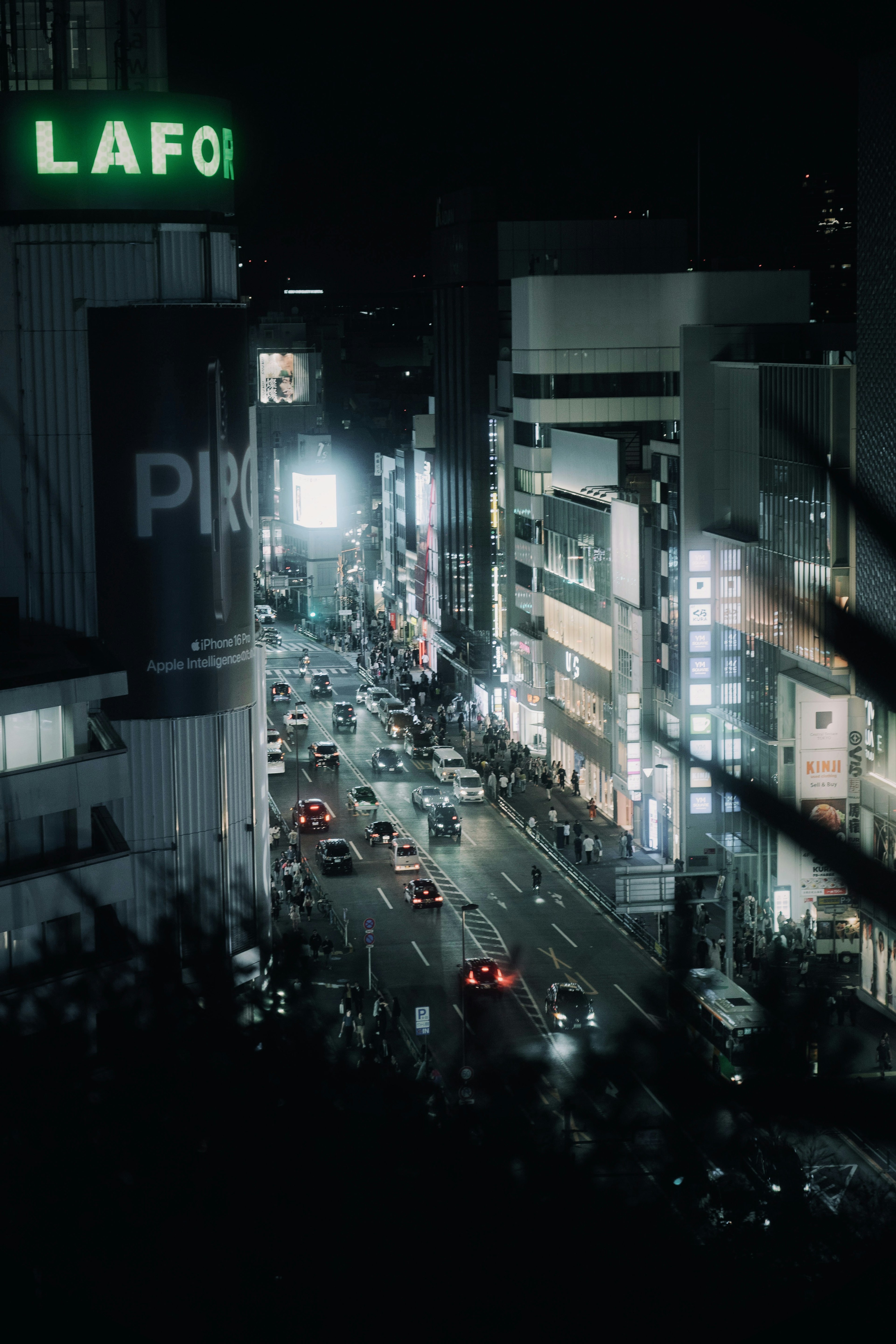 夜の都市風景　車の流れと明るい看板が特徴