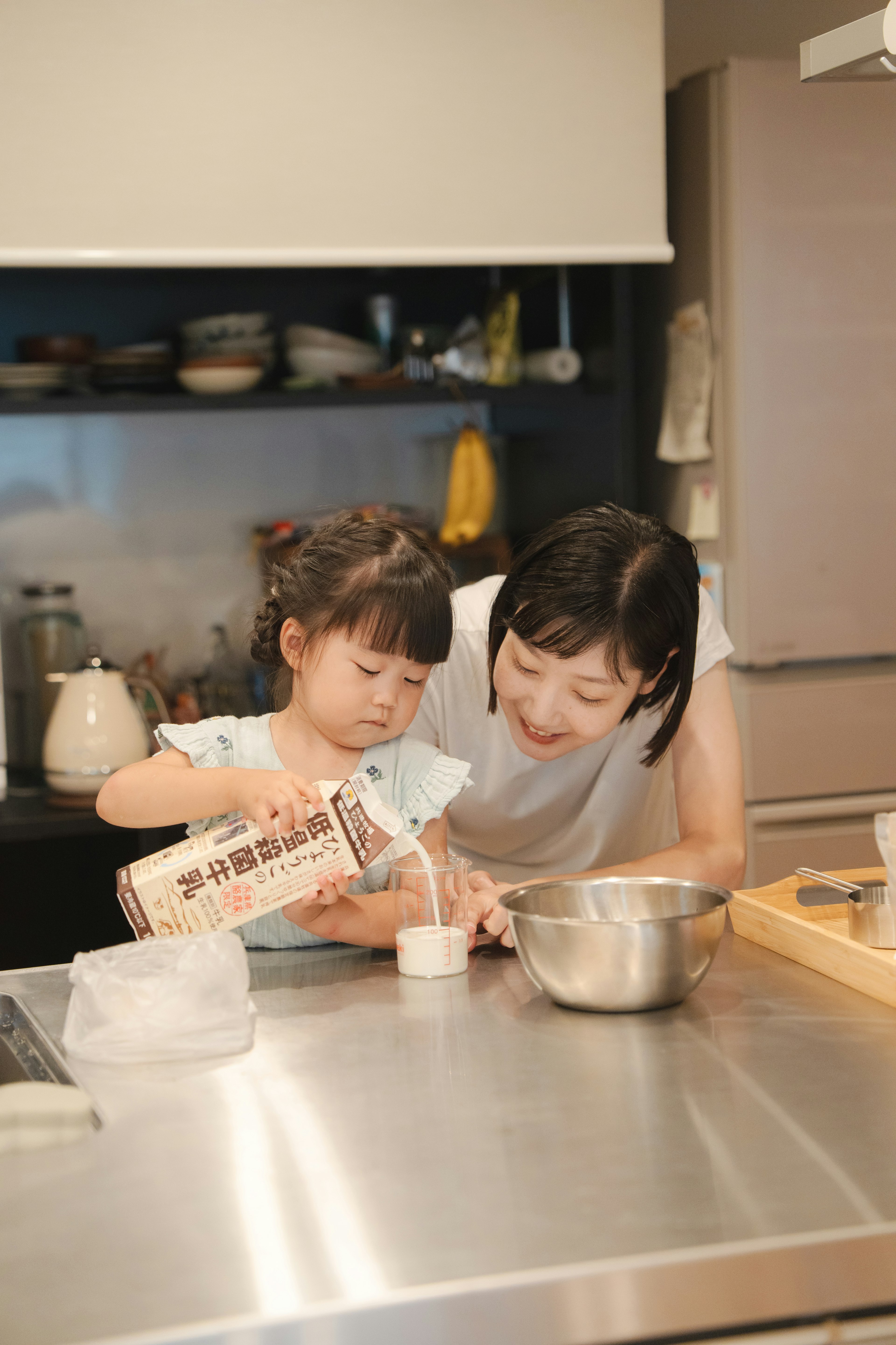 A mother and daughter cooking together in a kitchen