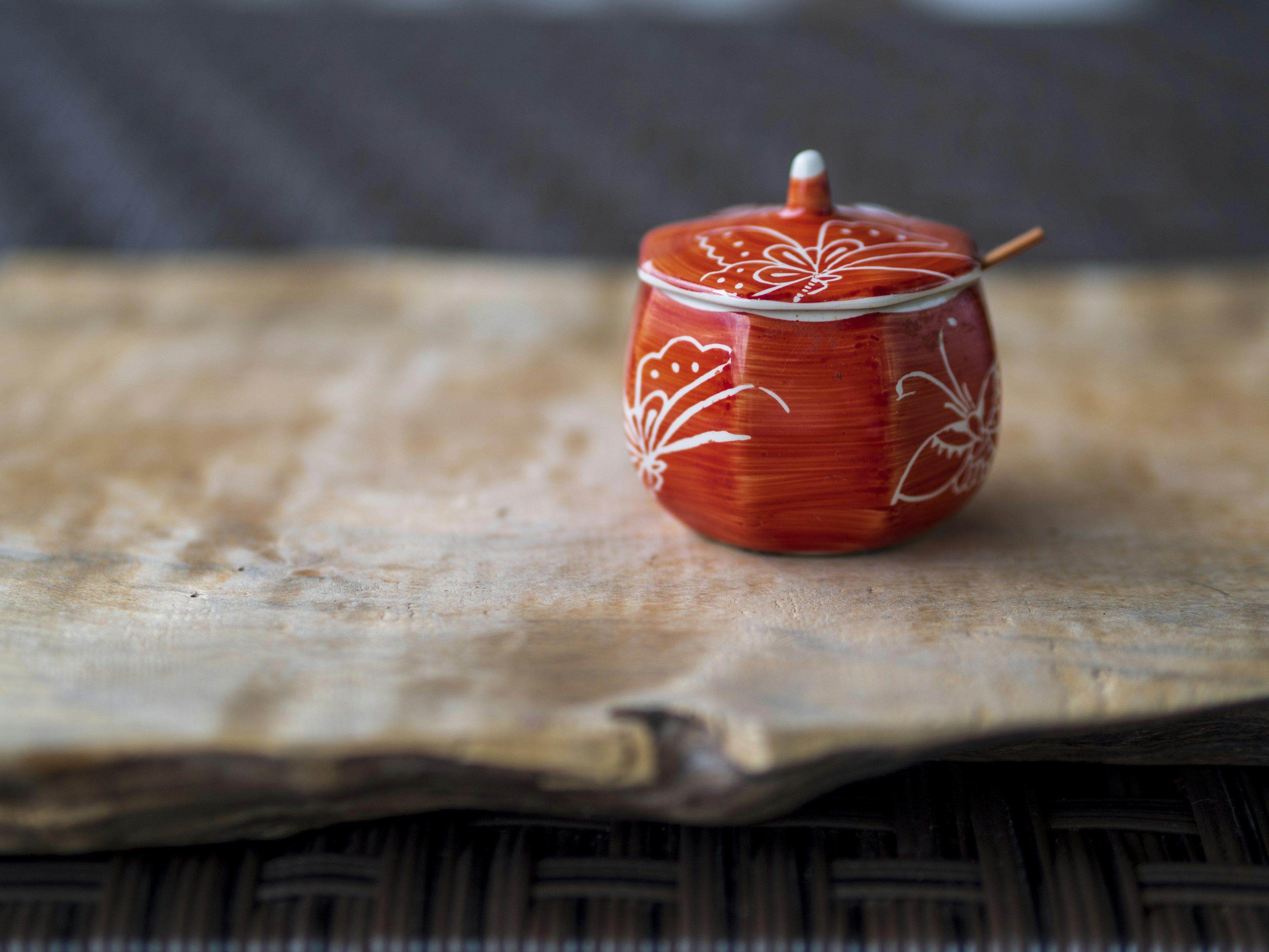 Contenedor de cerámica roja con patrones florales