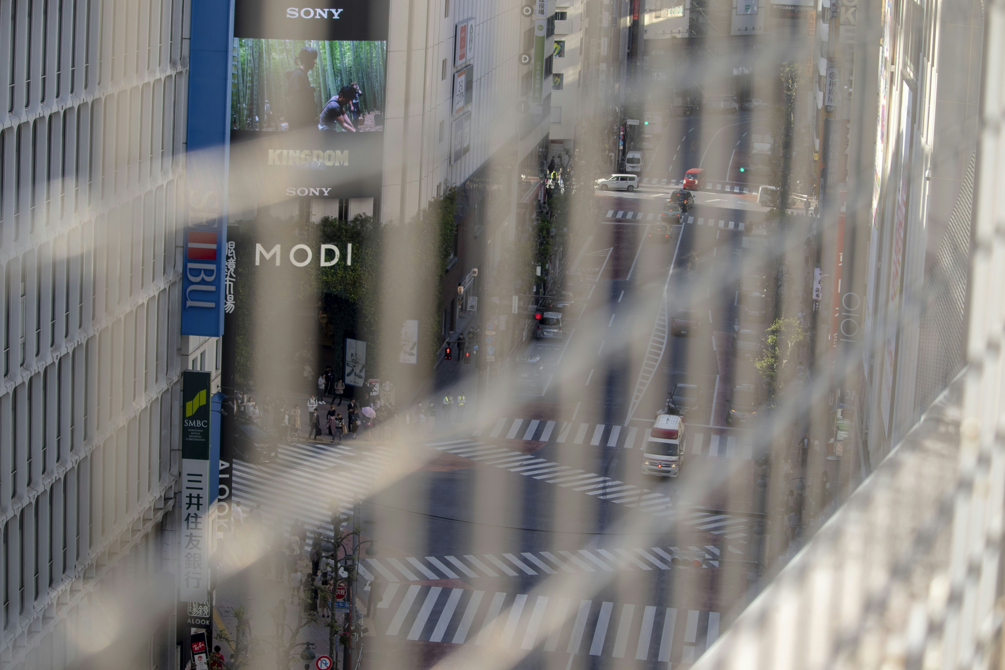 View of city street through a fence prominent MODI sign