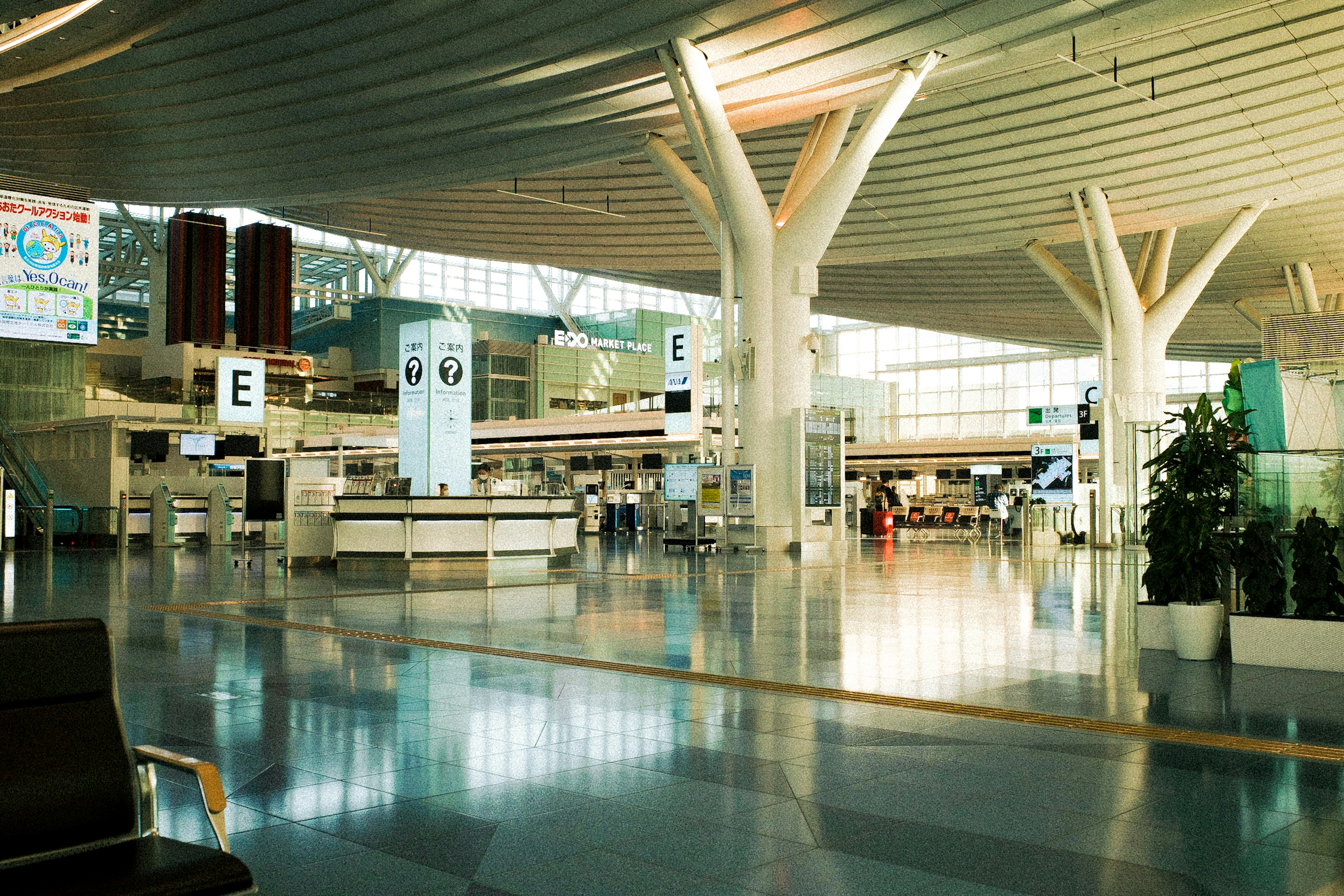 넓은 공항 내부, 밝은 조명과 현대적인 디자인, 체크인 카운터와 대기 공간이 보임