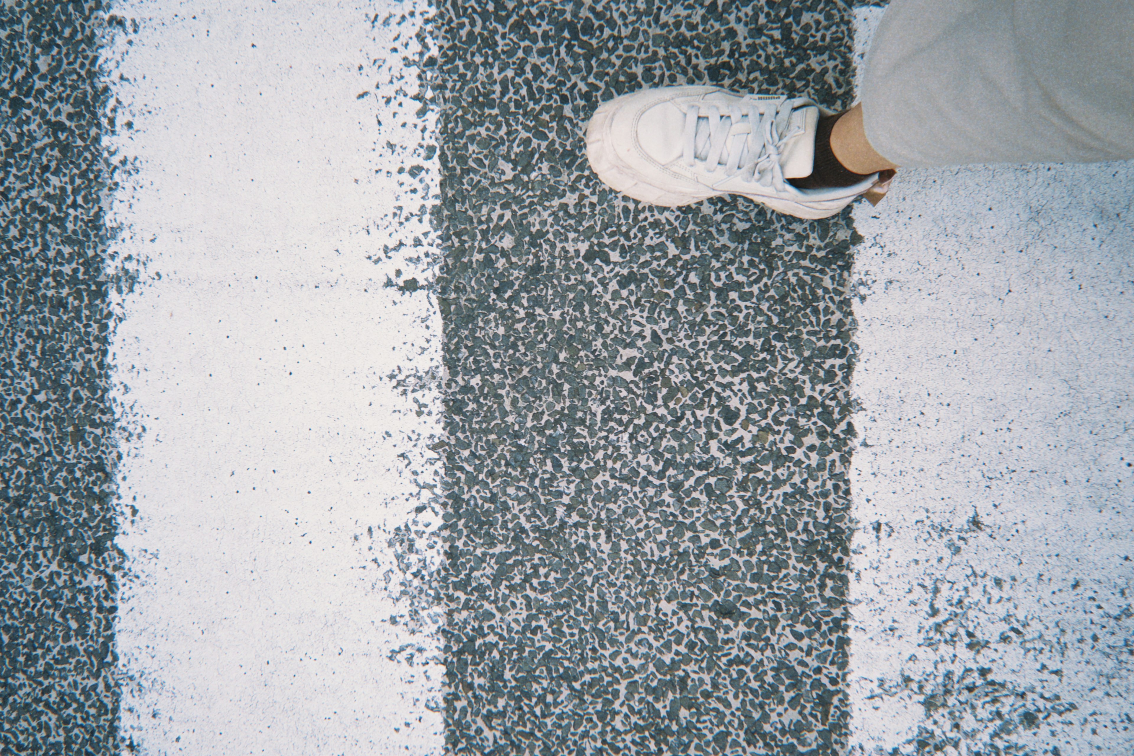 Foot on a crosswalk with white stripes