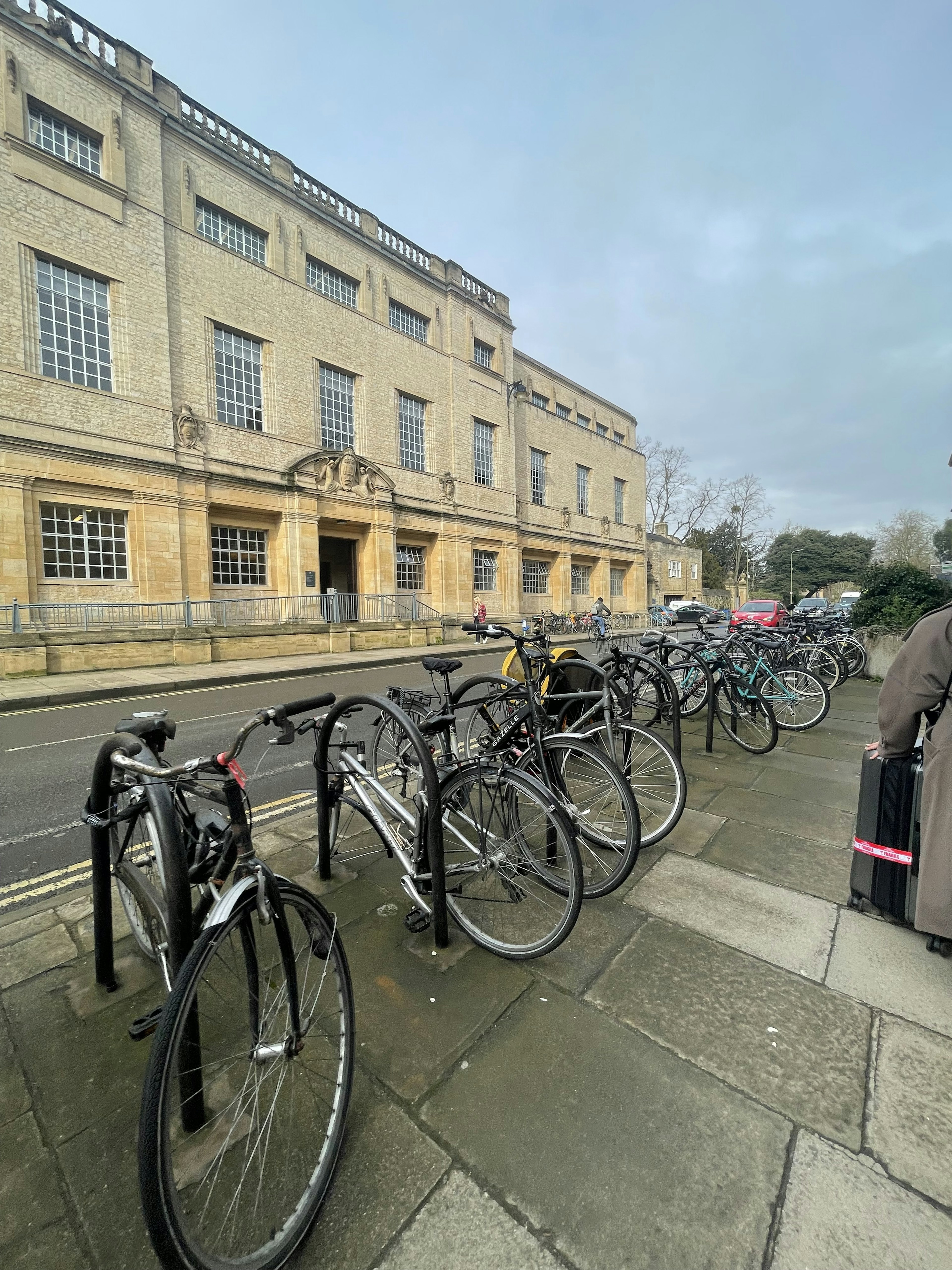 Biciclette allineate lungo una strada con un edificio storico