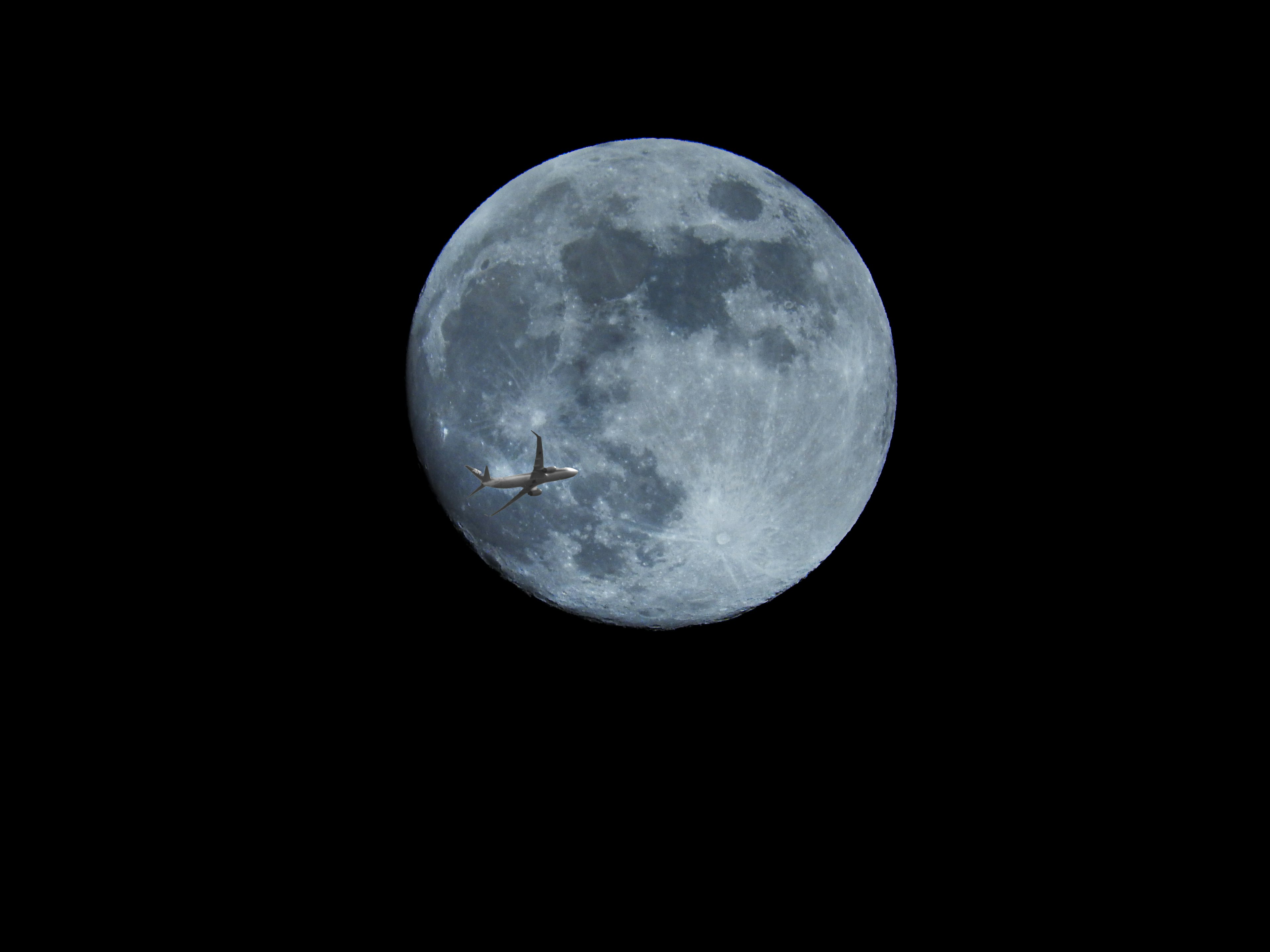 Lune bleue pleine avec un avion volant devant