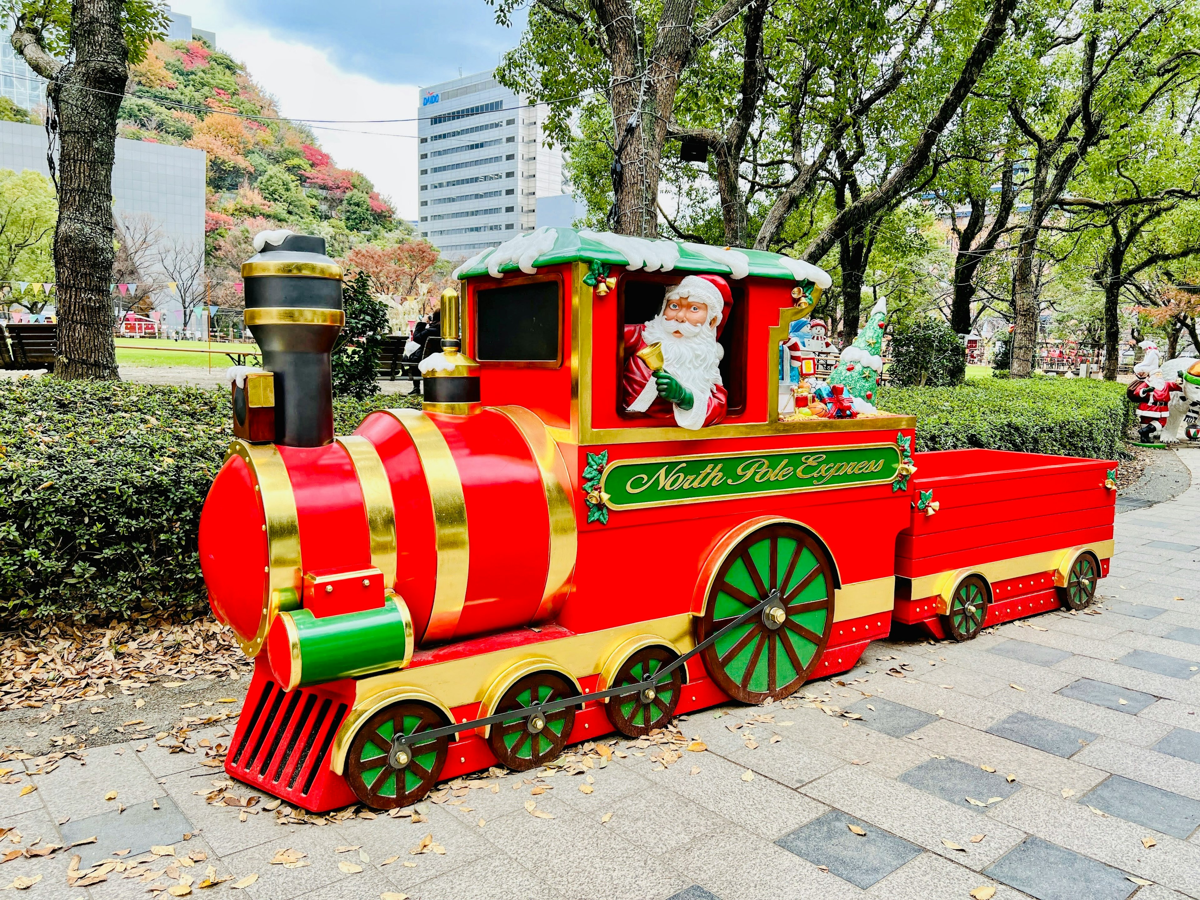 Kereta Natal berwarna-warni dengan Santa Claus di taman