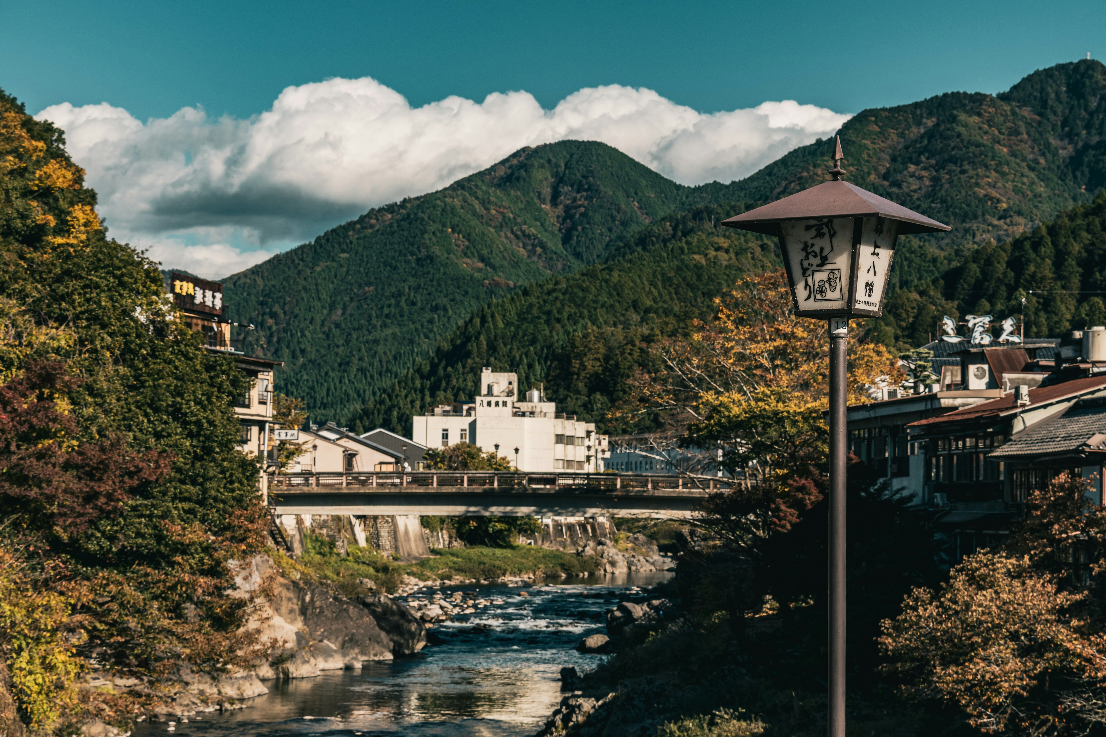 Serene village landscape surrounded by mountains with a river