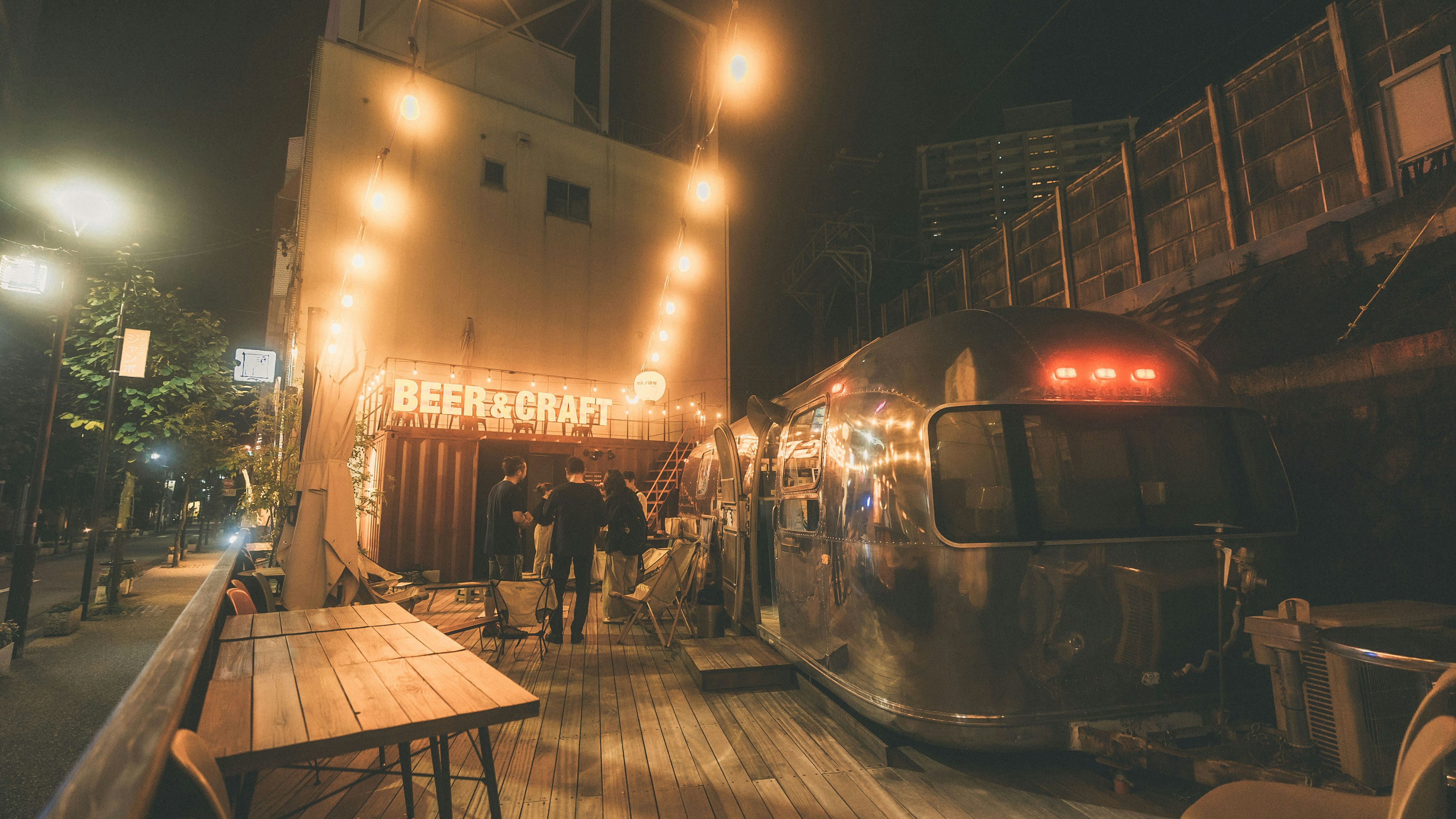 Food truck and restaurant with bright lights in a nighttime street scene