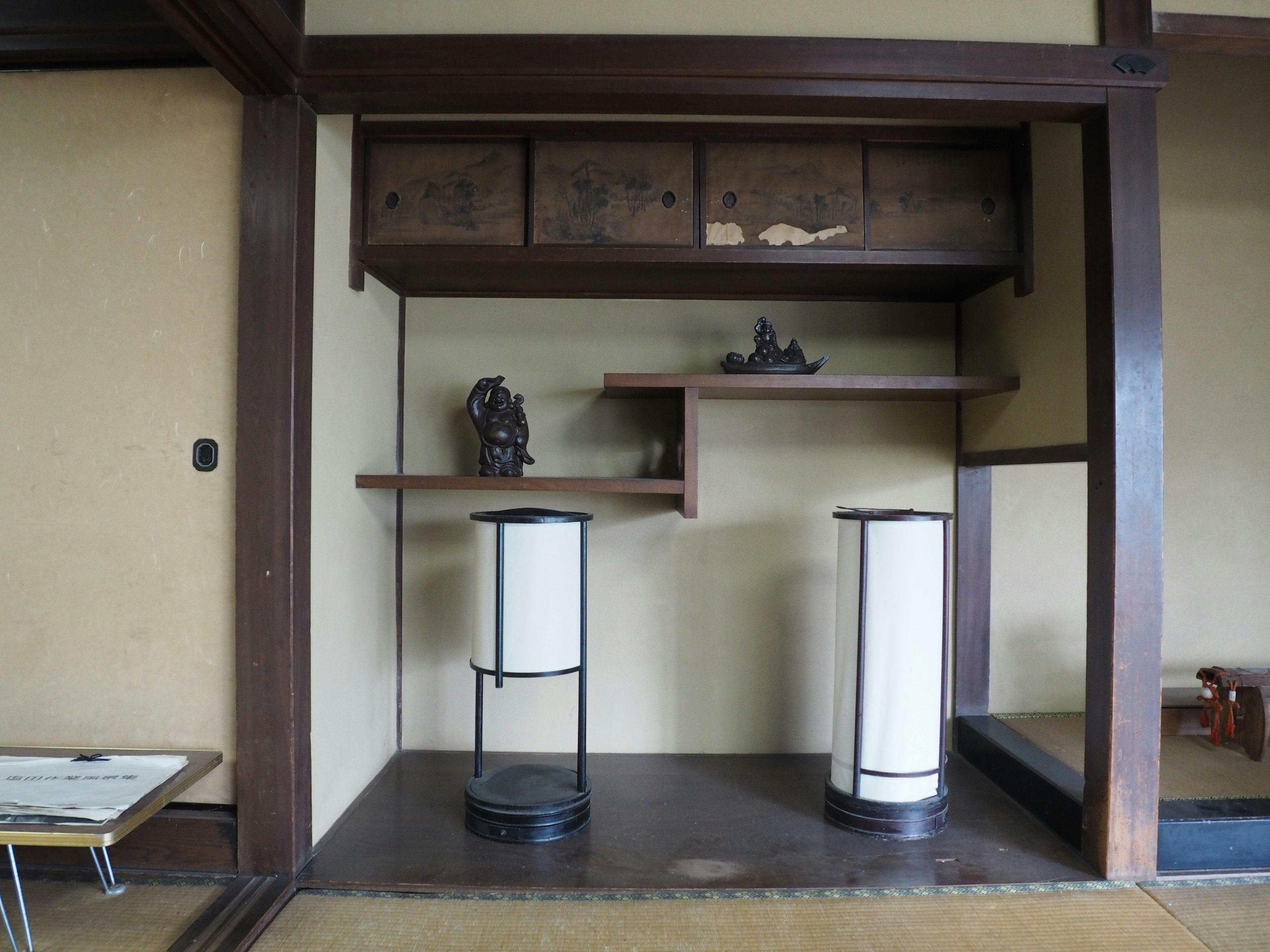 Traditional Japanese room interior featuring wooden shelves and light stands