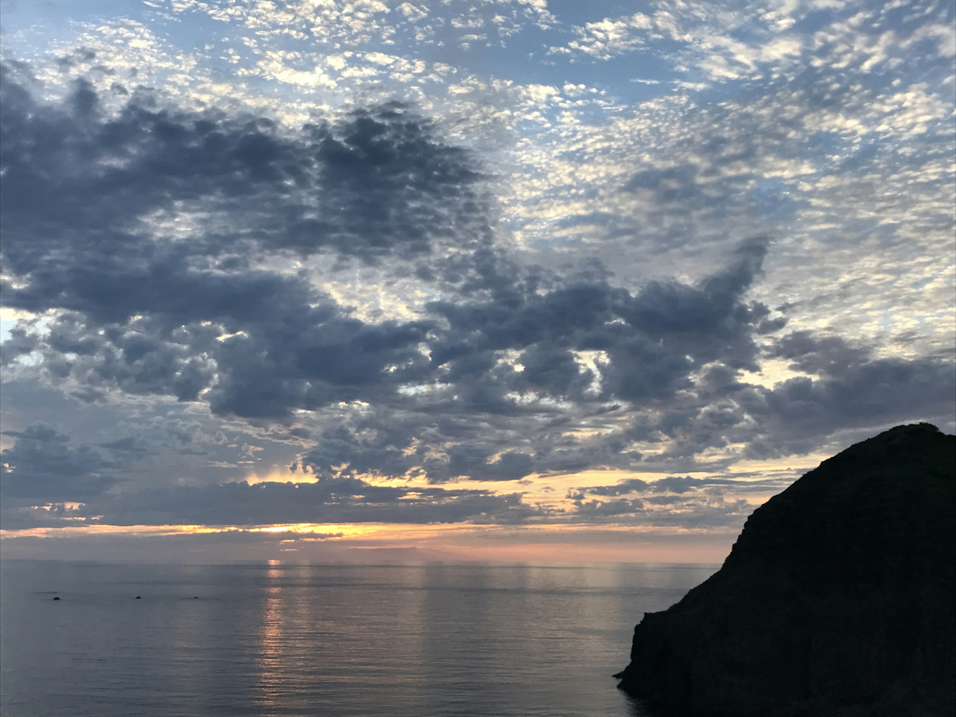 Hermoso paisaje marino al atardecer con nubes y agua tranquila