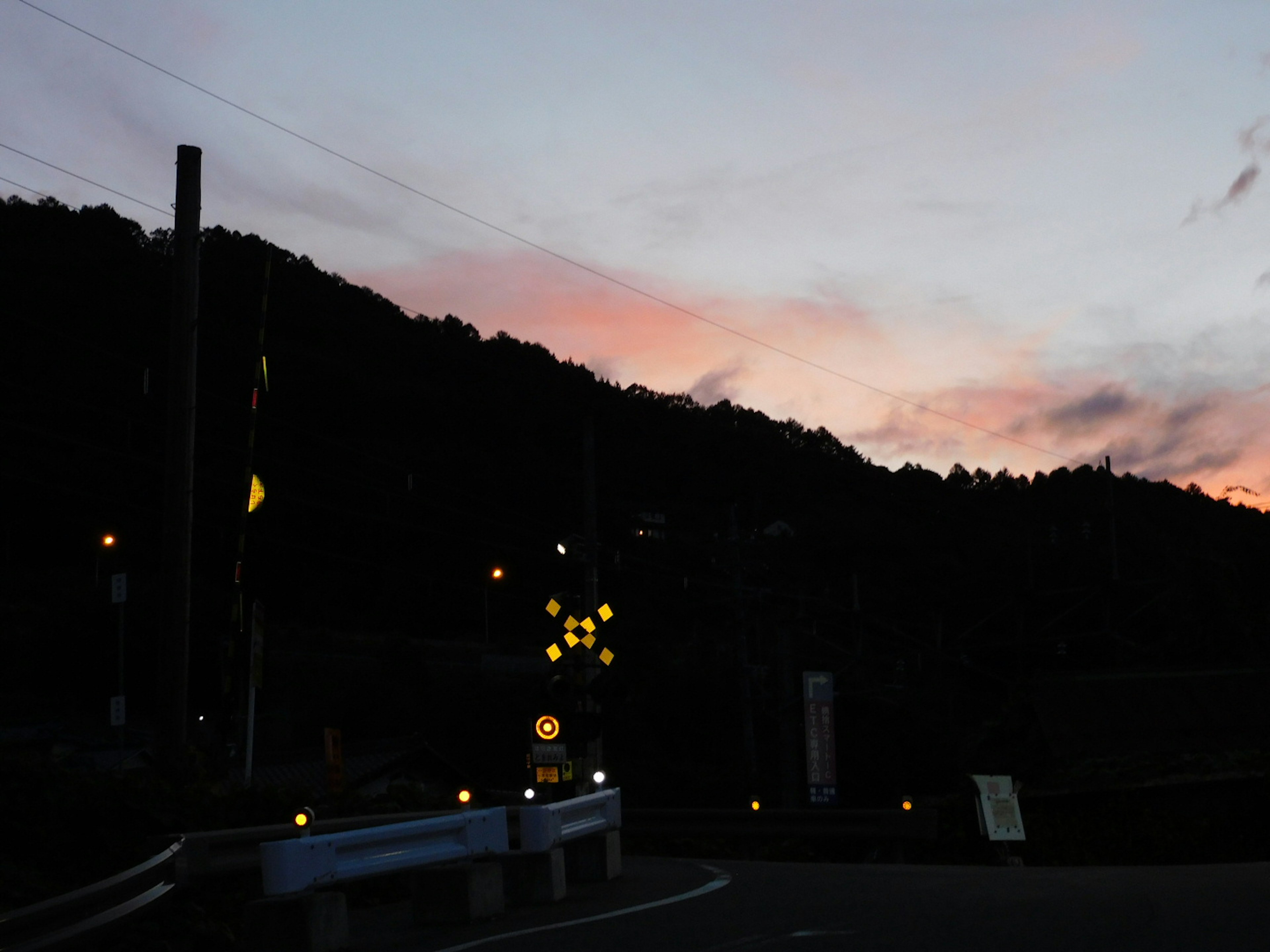 Silueta de montañas contra un cielo al atardecer con luces