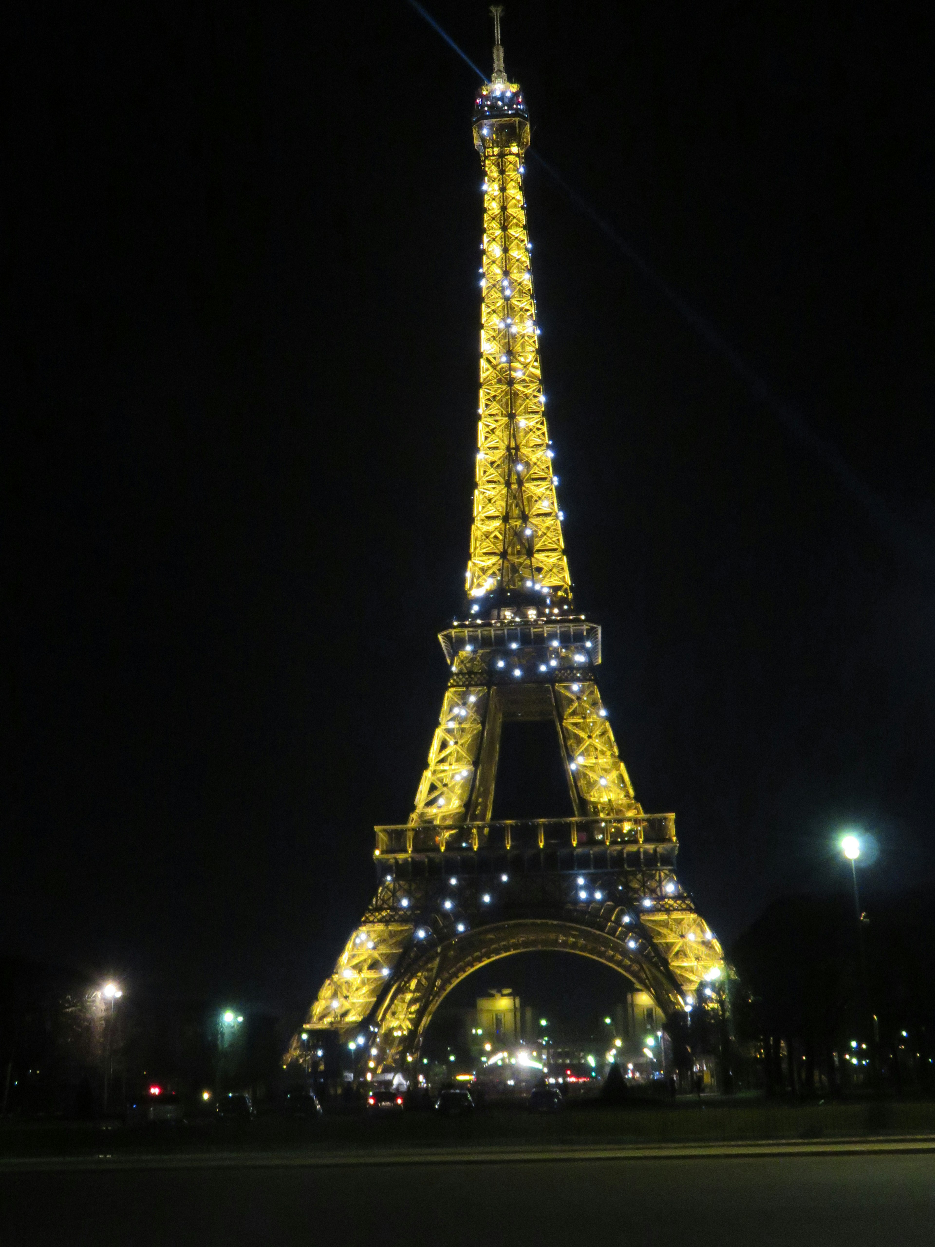 Torre Eiffel illuminata di notte con luci brillanti