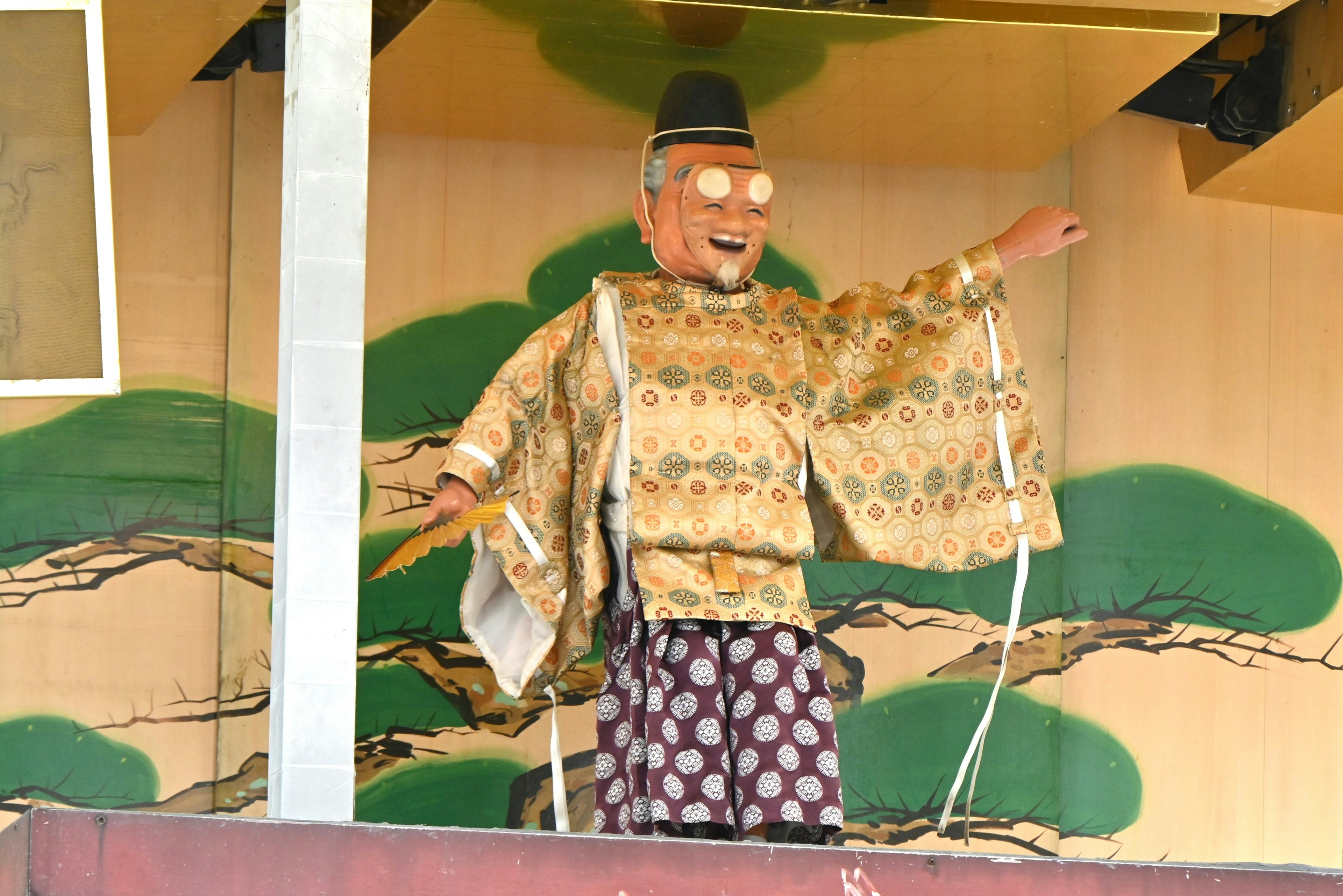 Una marioneta con atuendo tradicional saludando en el escenario