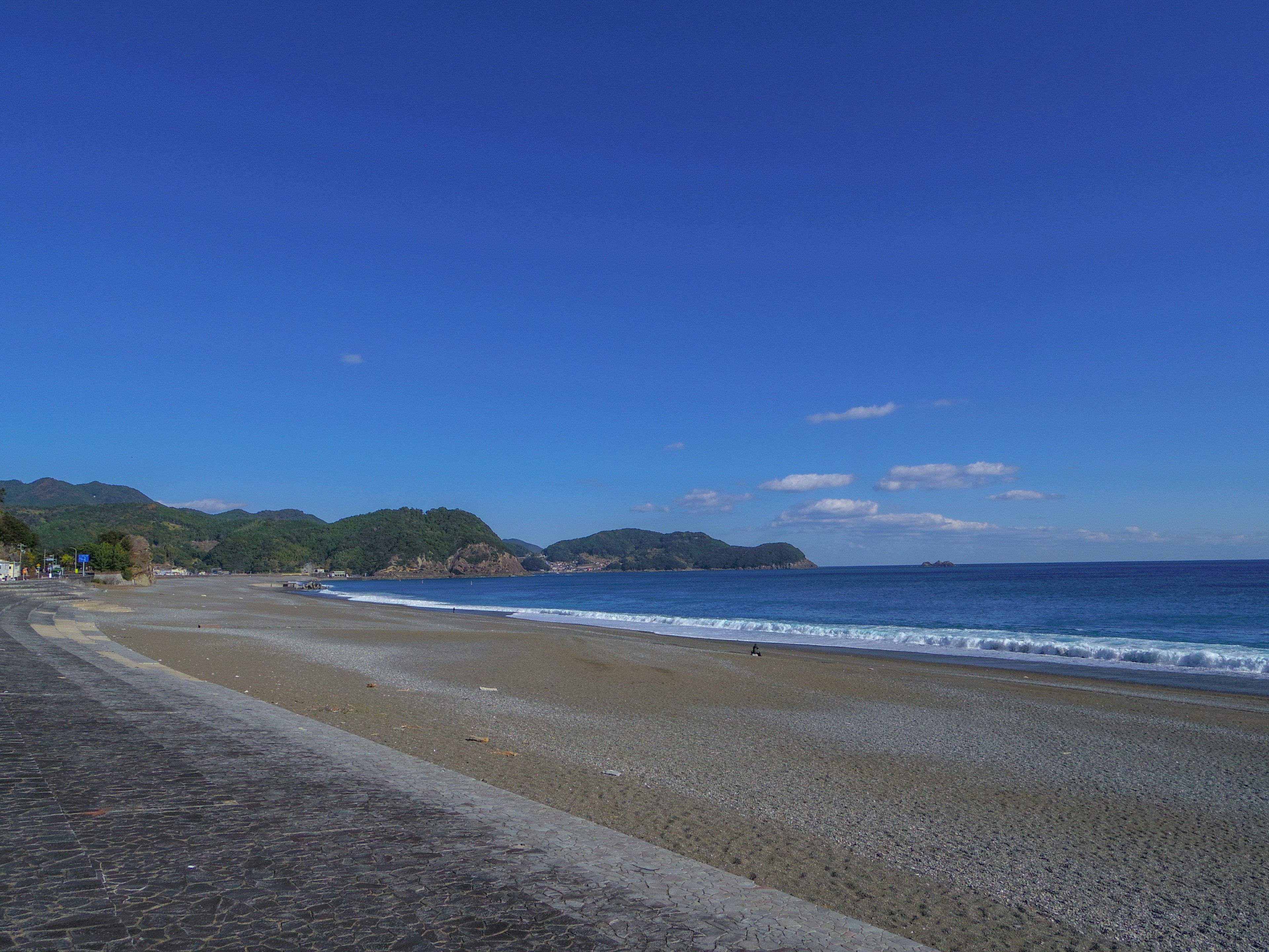 Malersiche Strandansicht mit blauem Himmel und ruhigem Meer