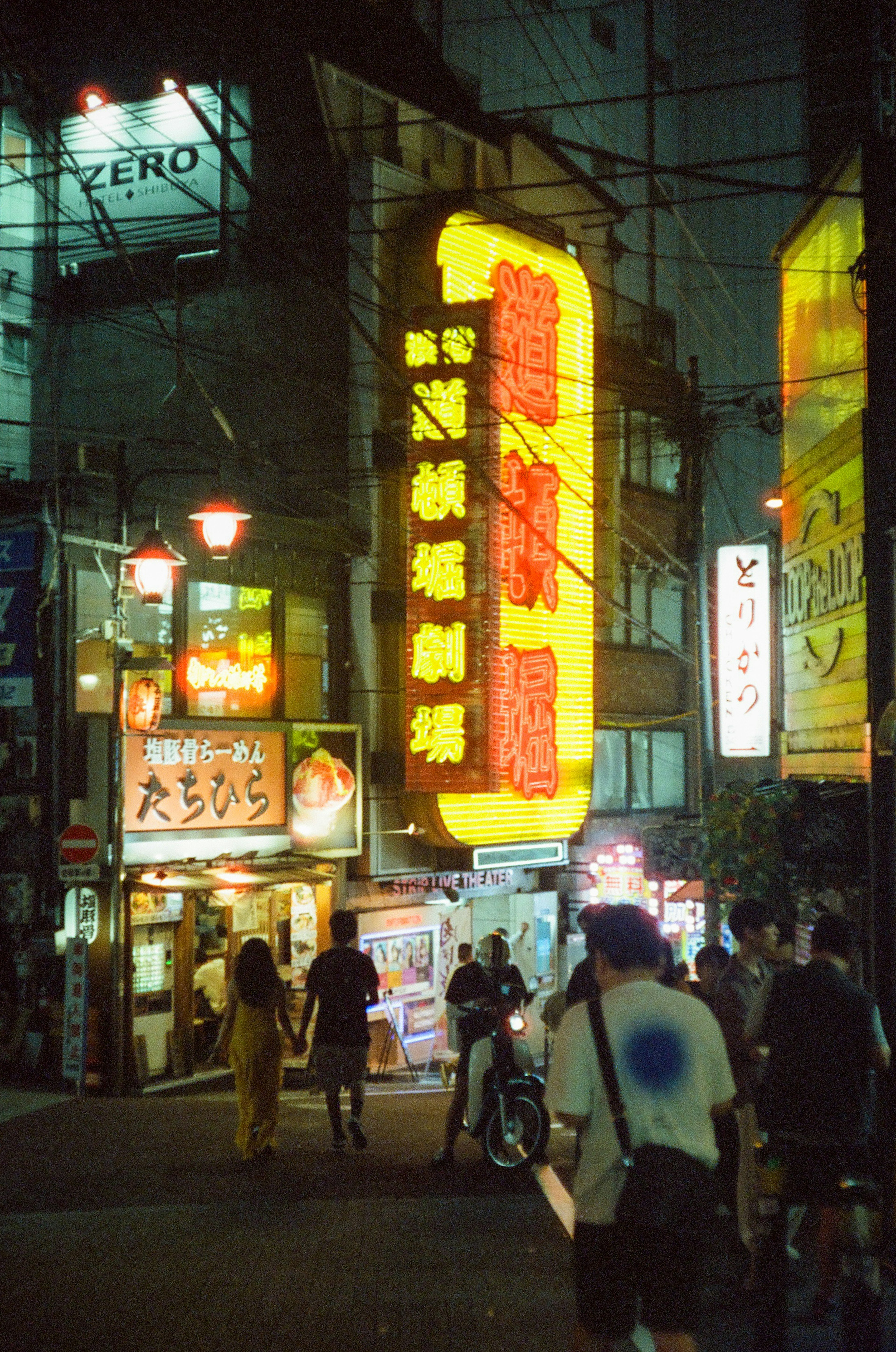 夜の繁華街にある明るい看板と人々の姿