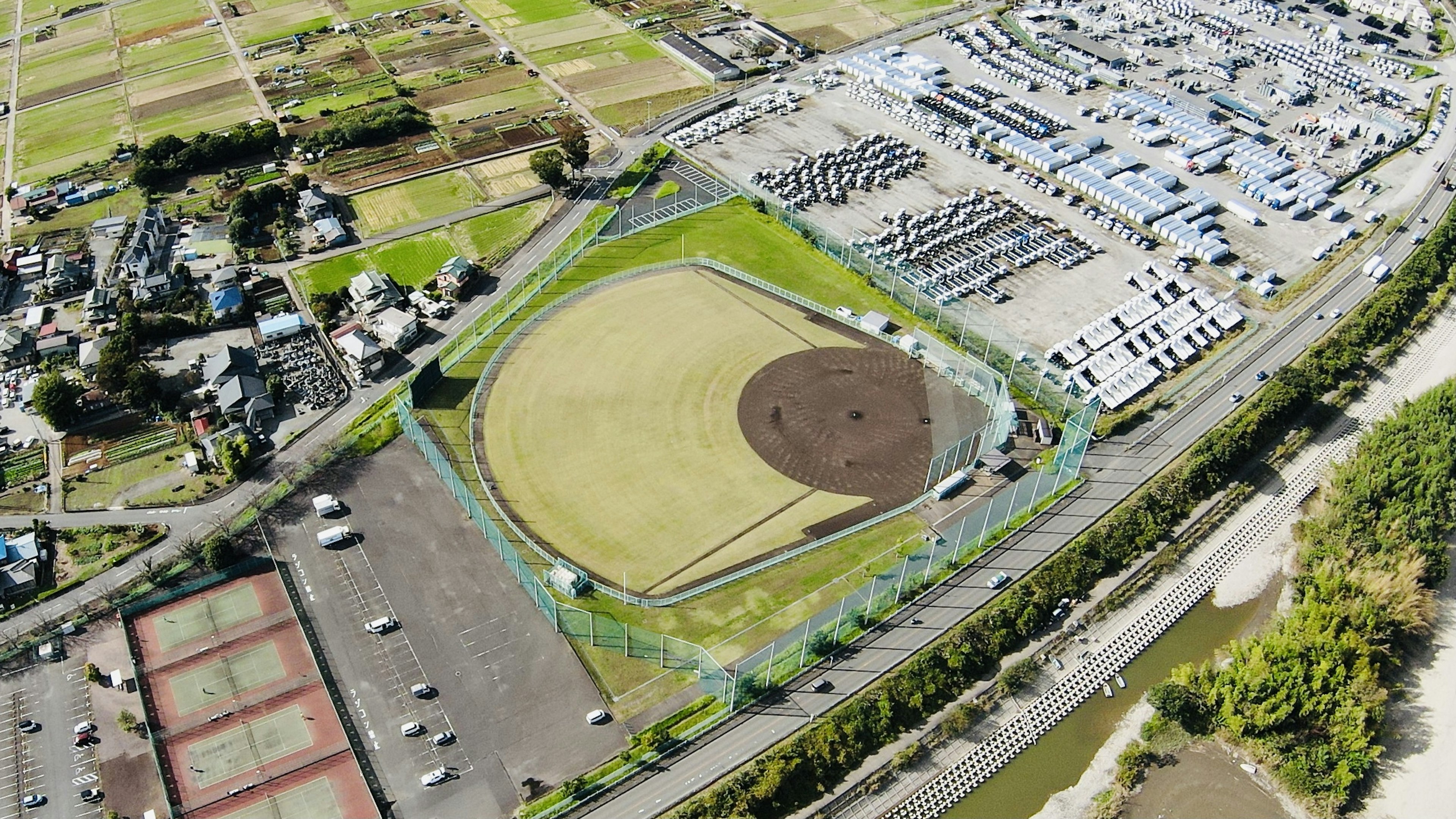 Luftaufnahme eines großen Baseballfeldes umgeben von Parkplätzen und landwirtschaftlichem Gelände