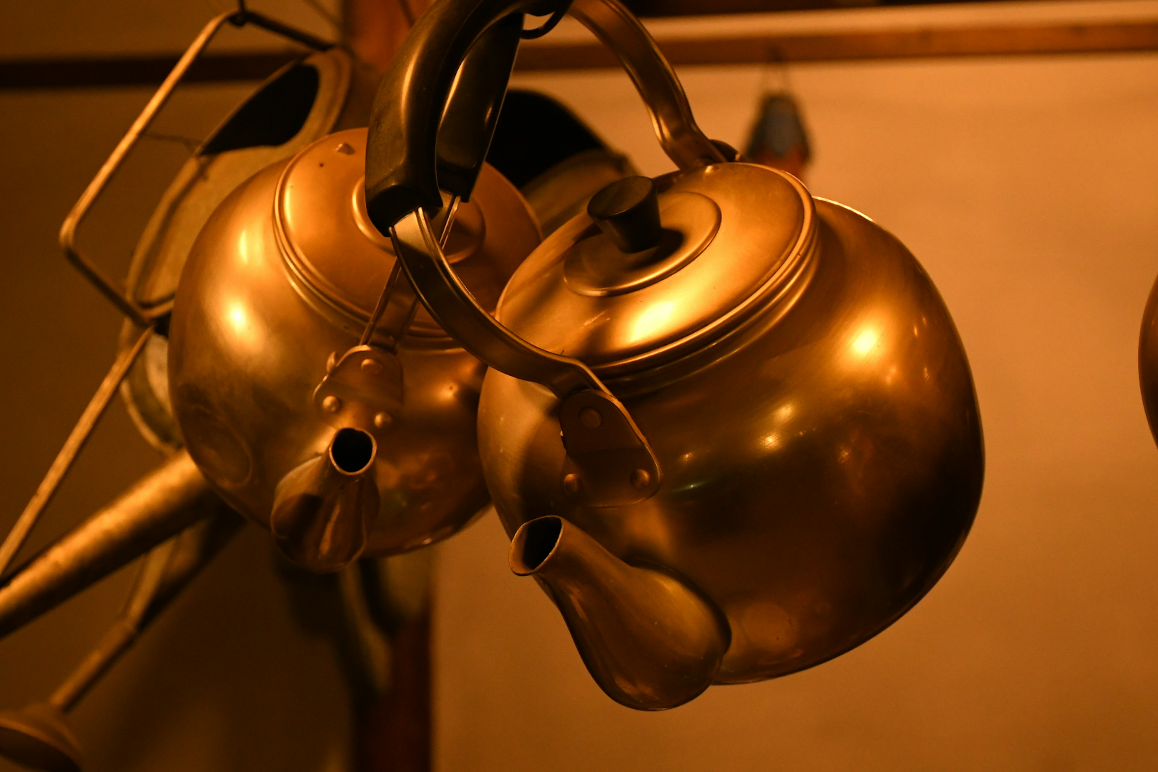 Two golden kettles hanging together