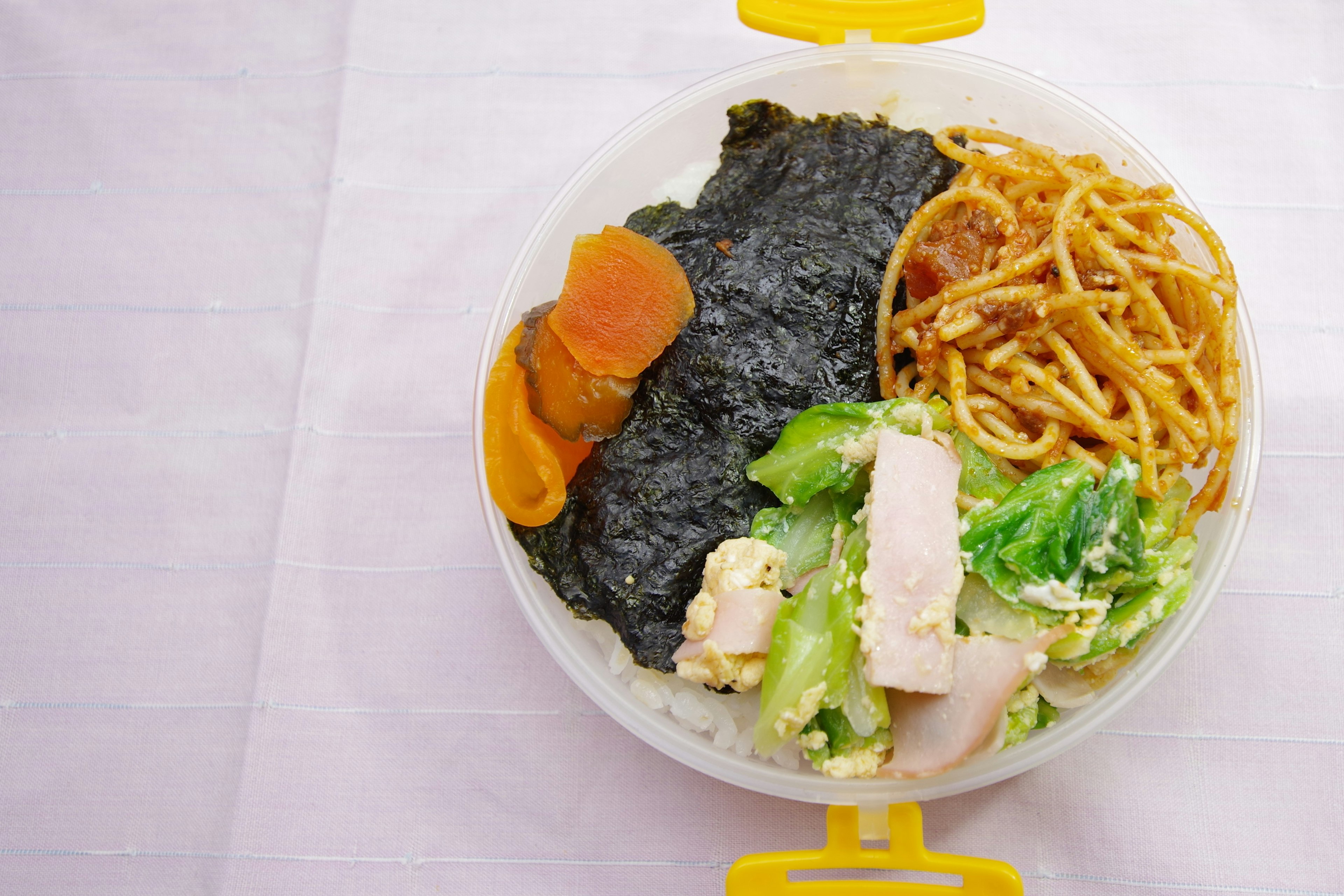 Balanced lunchbox featuring seaweed, spaghetti, chicken, salad, and carrot slices